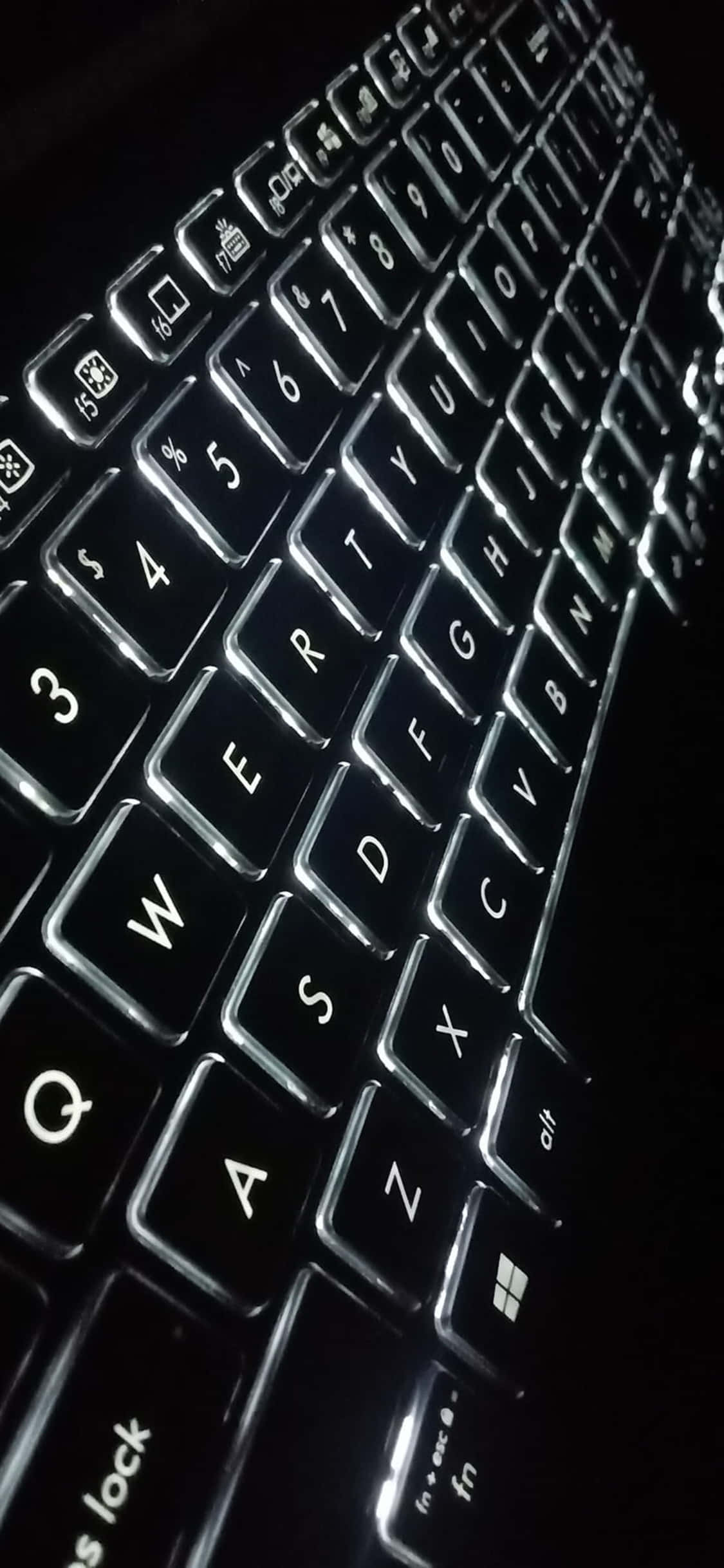 isang close up ng isang keyboard sa dilim Wallpaper