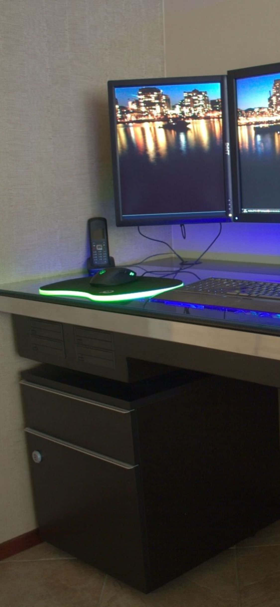 isang computer desk na may dalawang monitor Wallpaper