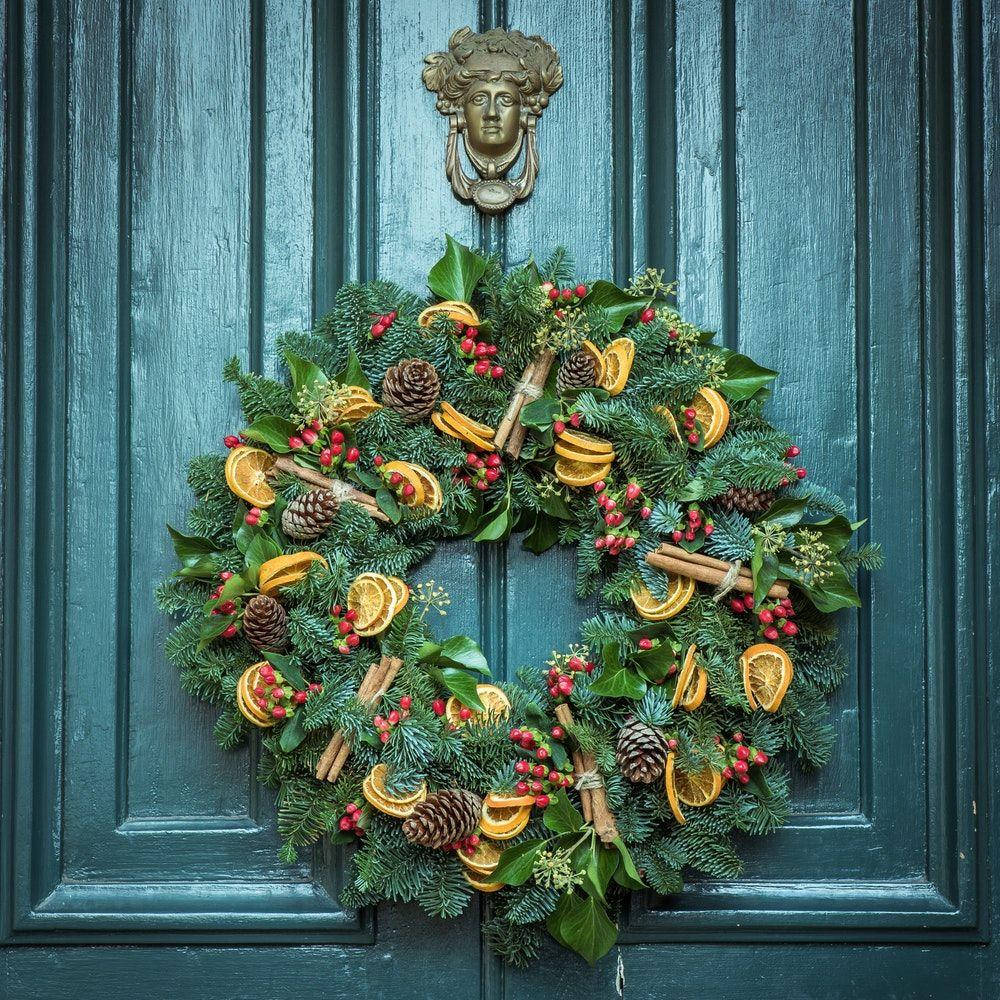 Isang Magandang Christmas Wreath na Pinalamutian ng mga Zesty Orange Slices Wallpaper