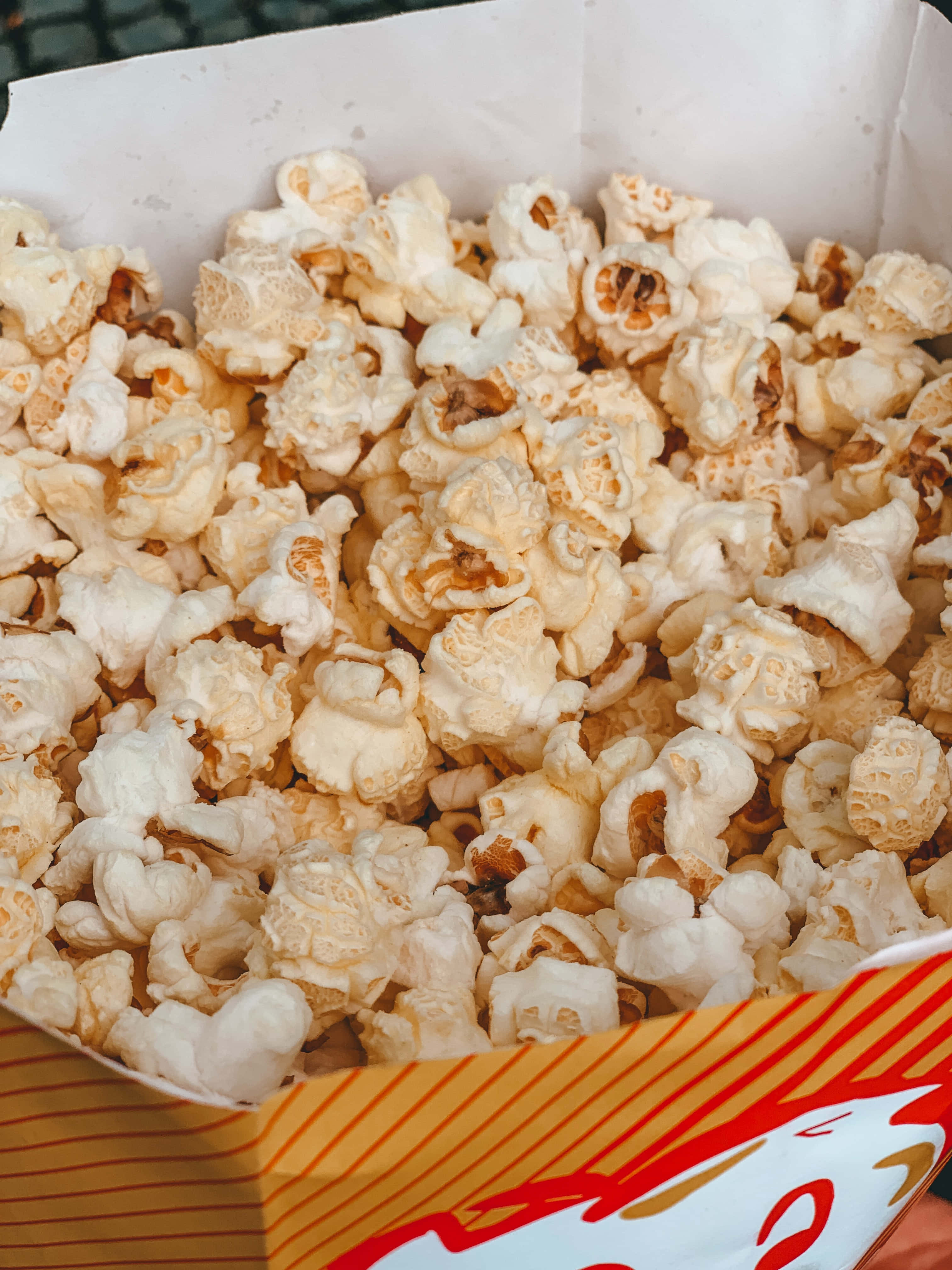 isang tao na humahawak ng isang kahon ng popcorn Wallpaper