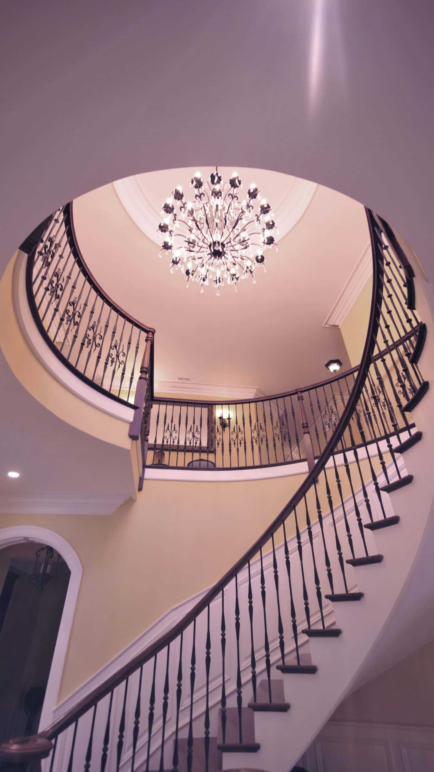 a staircase with a chandelier Wallpaper