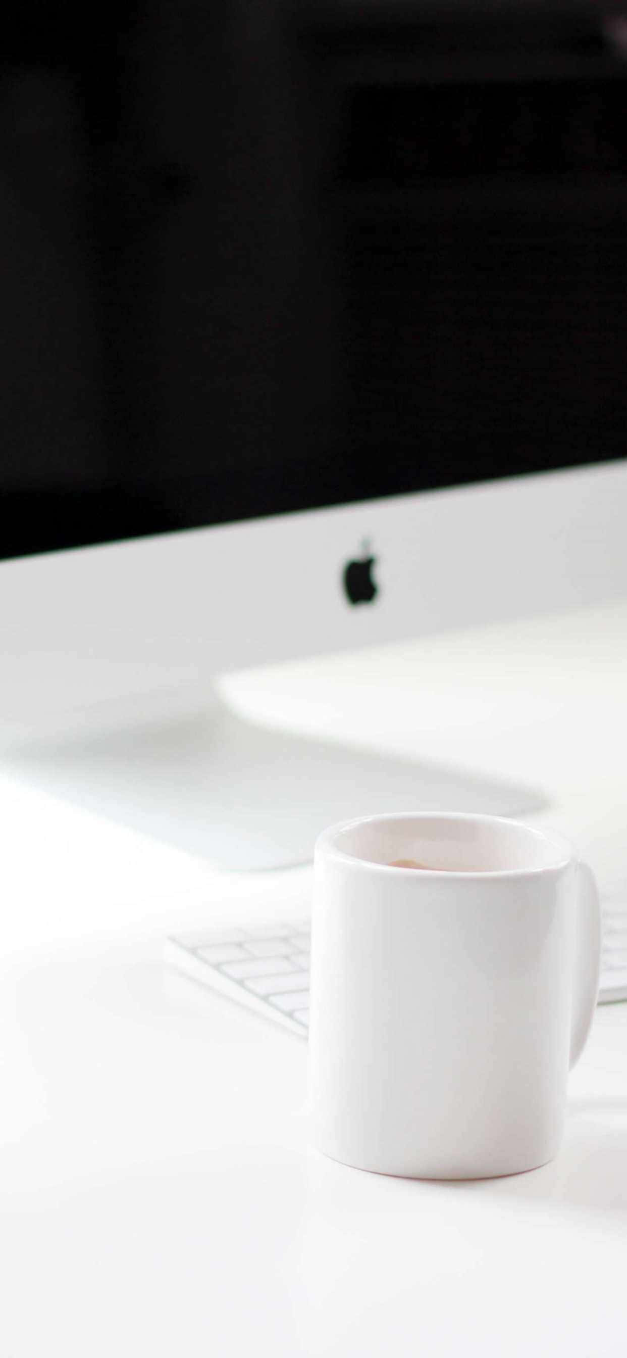 isang puting cup sa isang desk Wallpaper