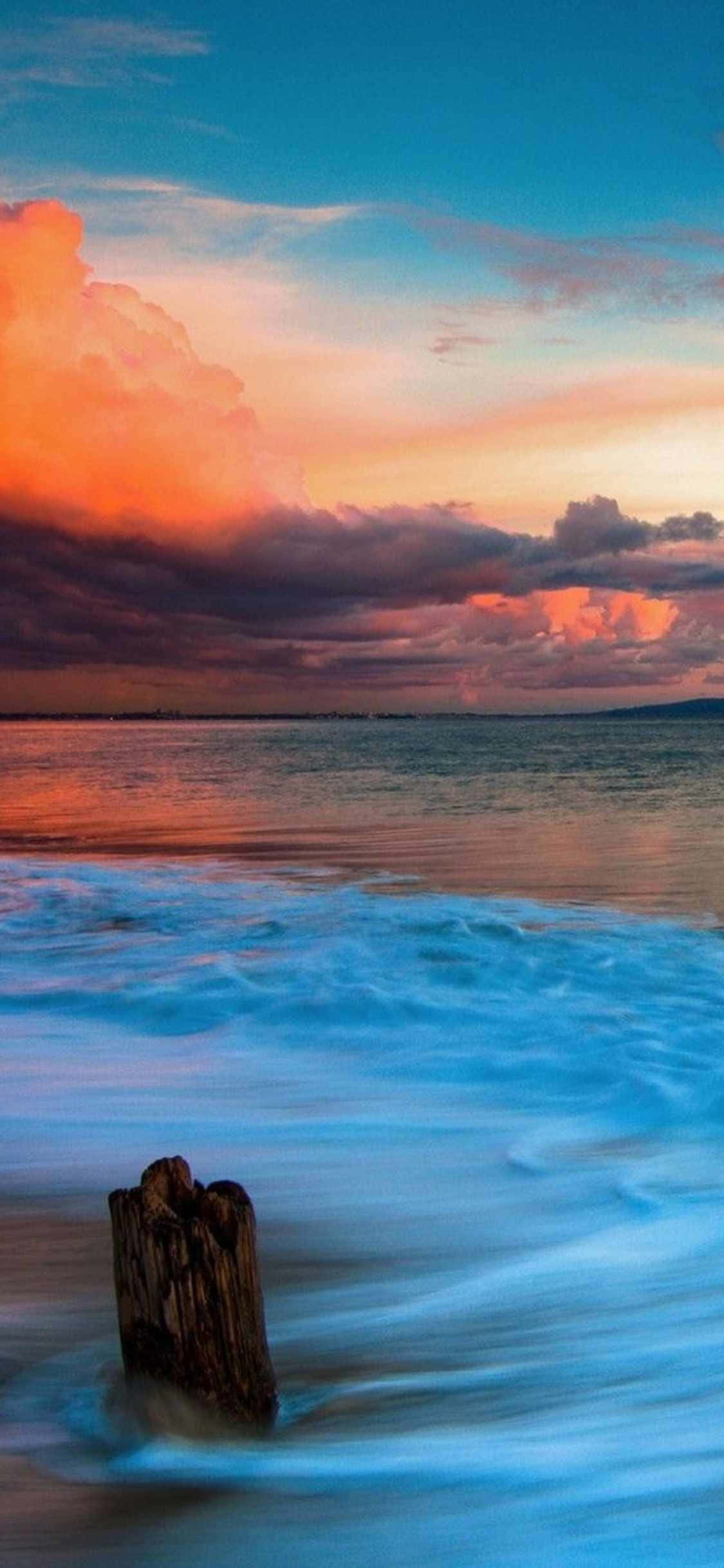 Isang idylikong paglubog ng araw sa Malibu, California na nakita sa lens ng isang iPhone Xs Wallpaper