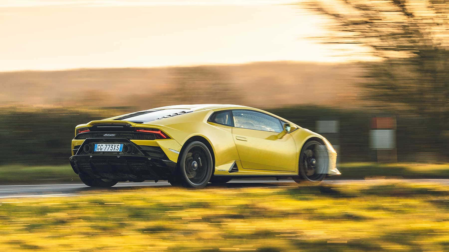Ang lamborghini huracan ay nagmamaneho pababa sa isang kalsadang pangbukid Wallpaper