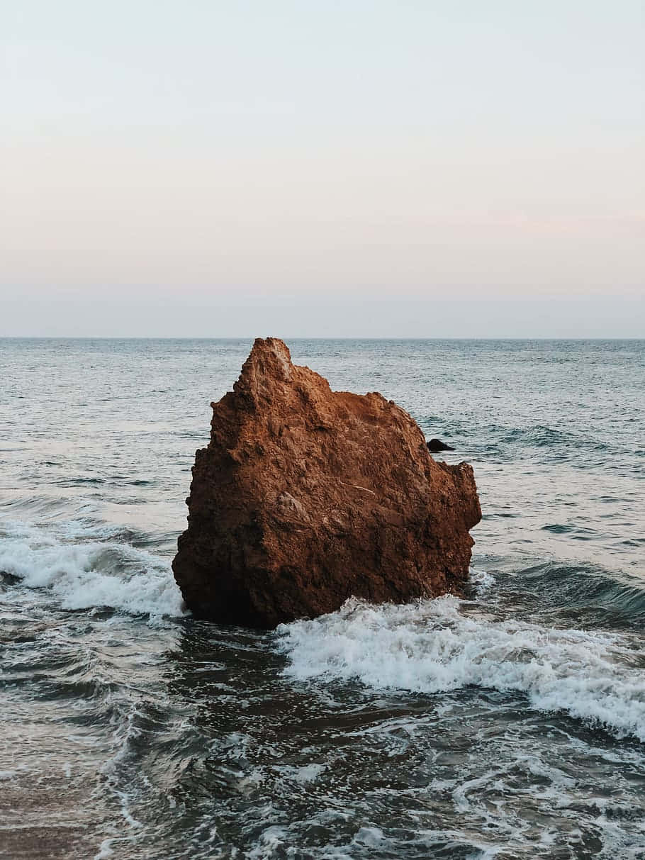 Background ng iPhone X Malibu na May Malaking Bato Wallpaper