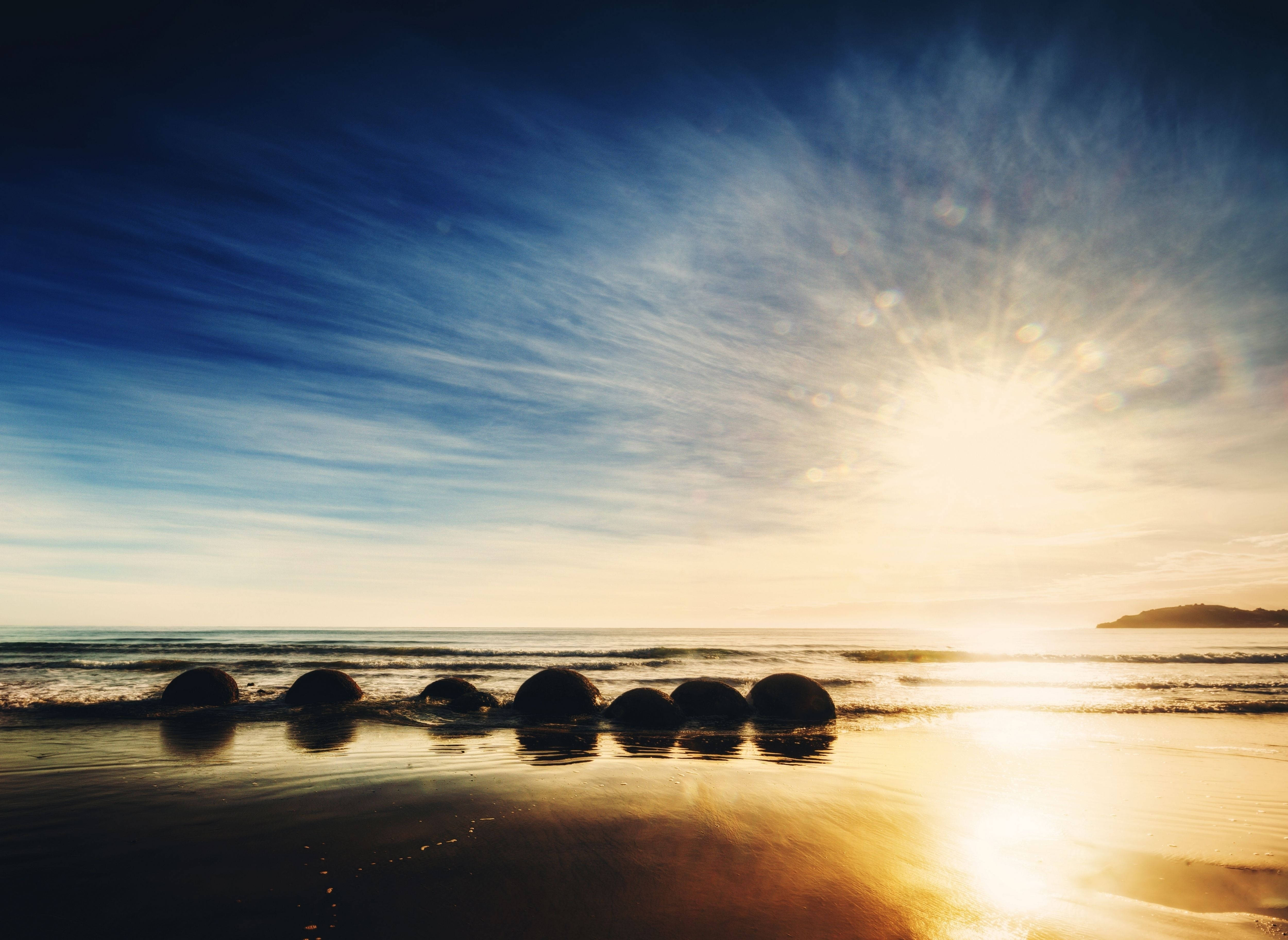 Bumangon kasama ng araw sa Moeraki Boulders Beach Wallpaper