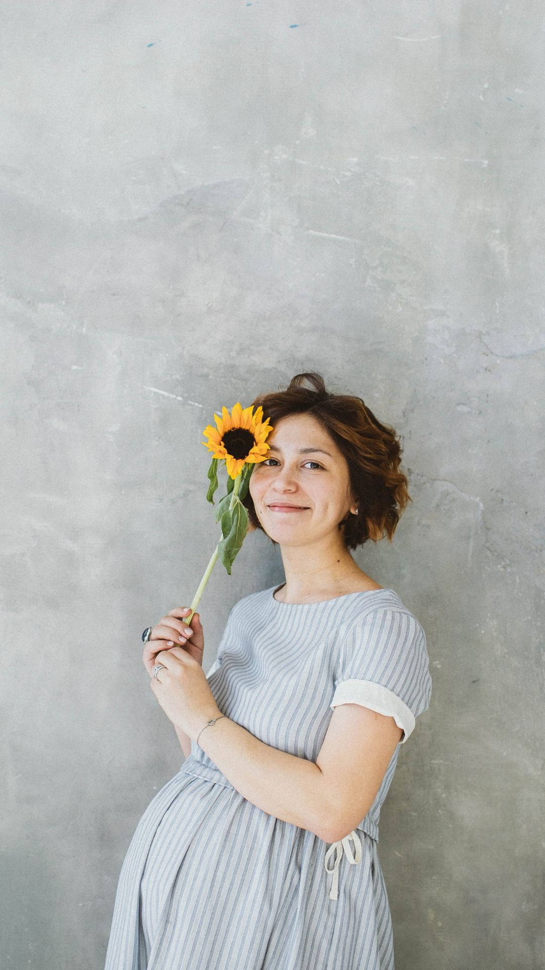 Buntis na Babae na May Hawak na Sunflower Wallpaper