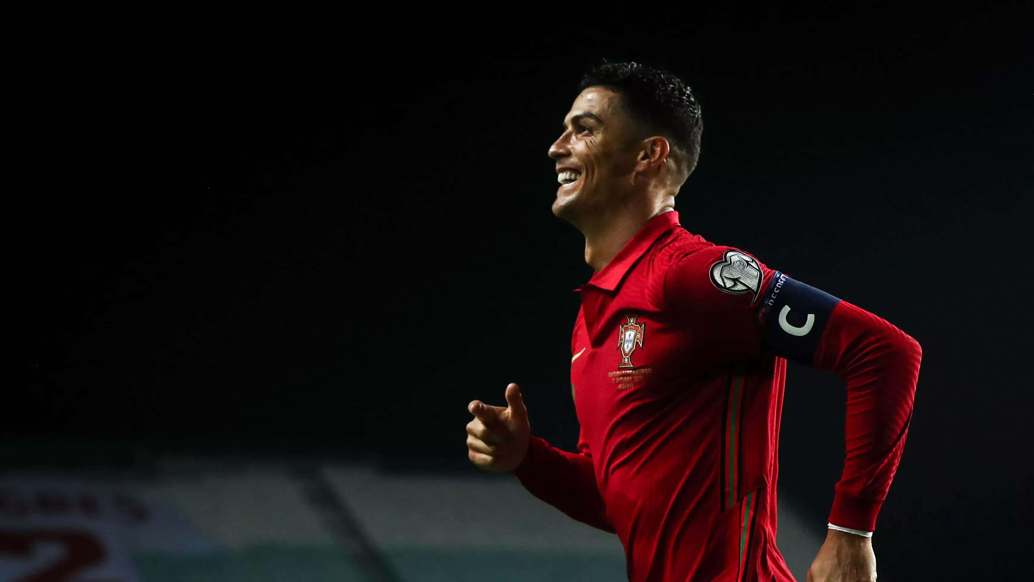 Cristiano Ronaldo tumatakbo sa larangan ng football Wallpaper