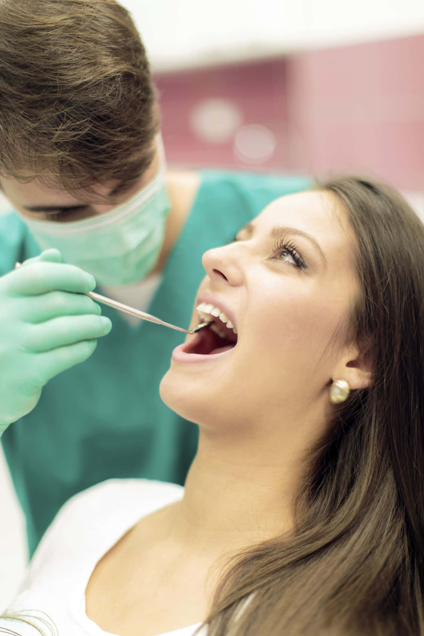 Dentista na nag-eeksamen ng pasyente gamit ang dental na mga kasangkapan Wallpaper