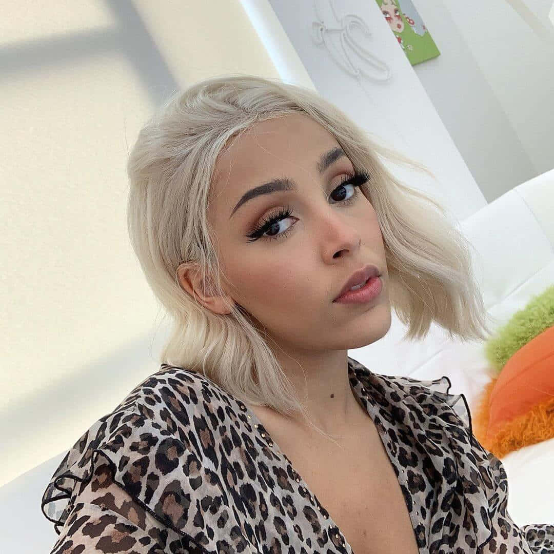 Doja Cat na nagpapakita ng kanyang kagandahan na may glitter eyeshadow at maliwanag na ngiti. Wallpaper
