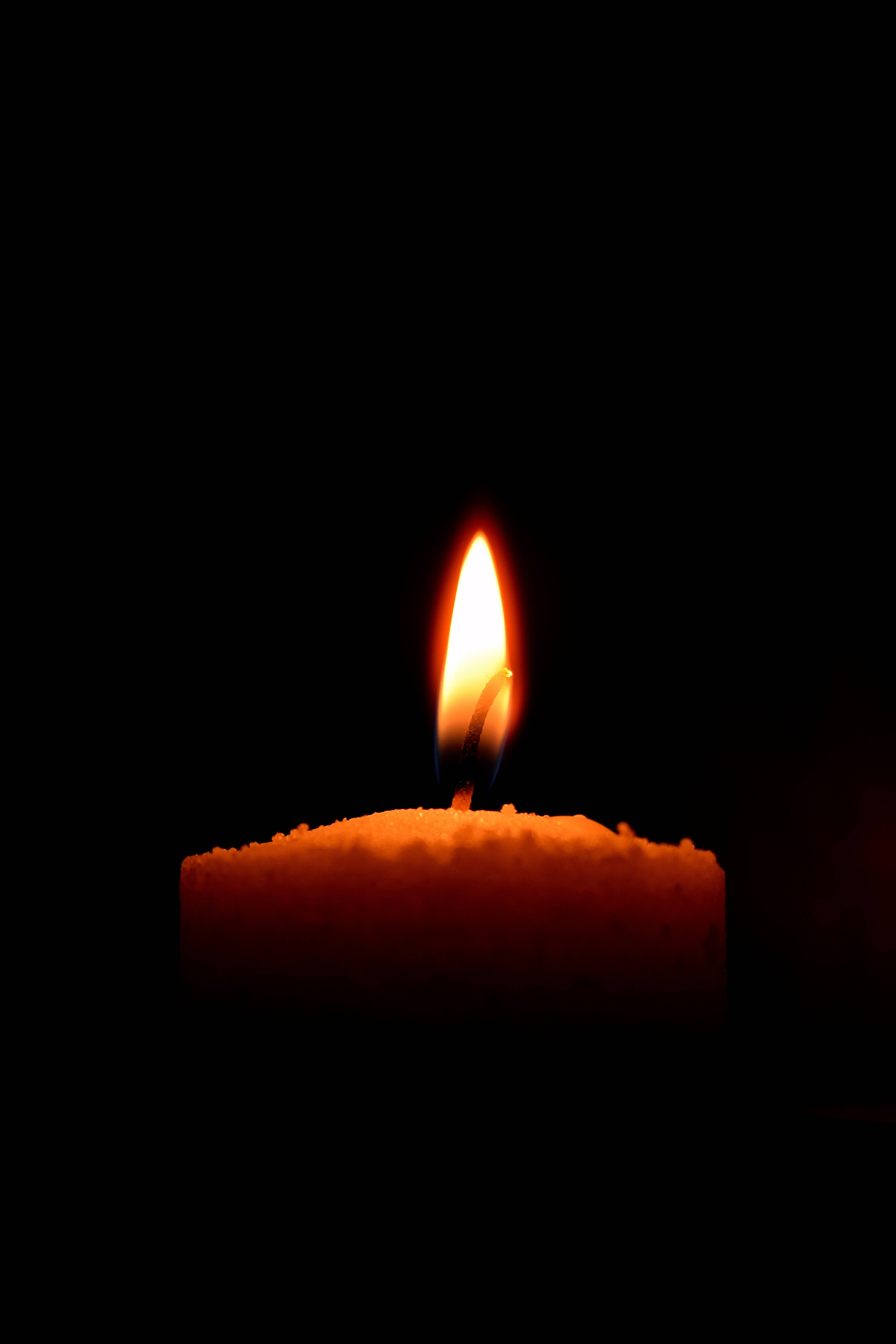 Magtatamasa ng Isang Mapayapang Sandali kasama ang Lighted Candle ni Dim Wallpaper