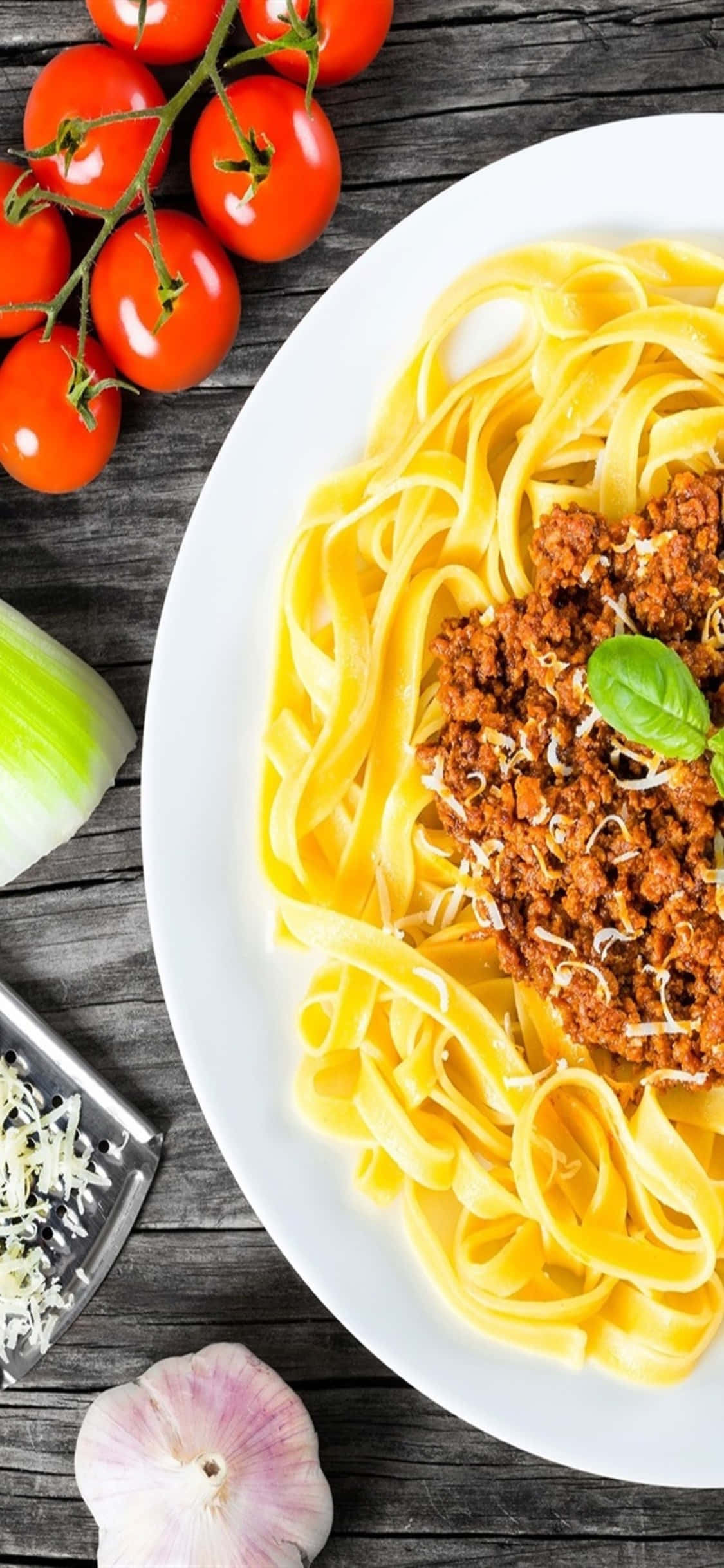 Epicurean Delight - Ang iPhone X na nagpapakita ng vibrant colors at delicious texture ng pasta. Wallpaper