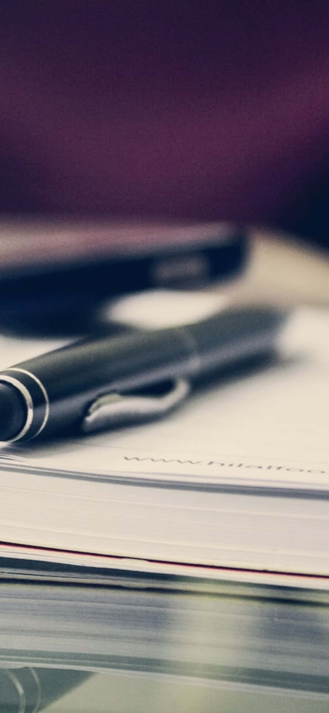 iPhone X Desk Background Pen On Top Of Book Wallpaper