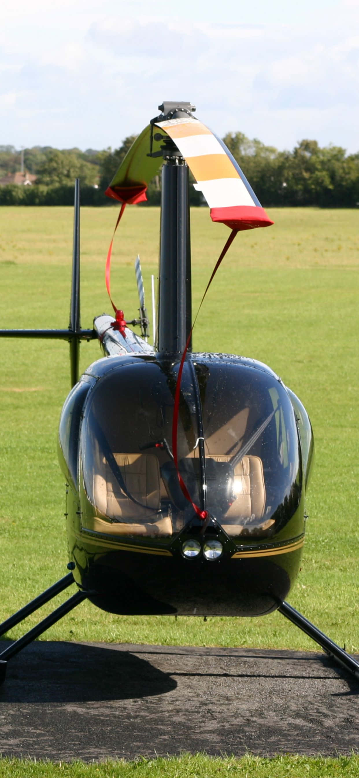 Isang aerial view ng isang gubat na parang na may helicopter na nag-hover sa itaas nito. Wallpaper