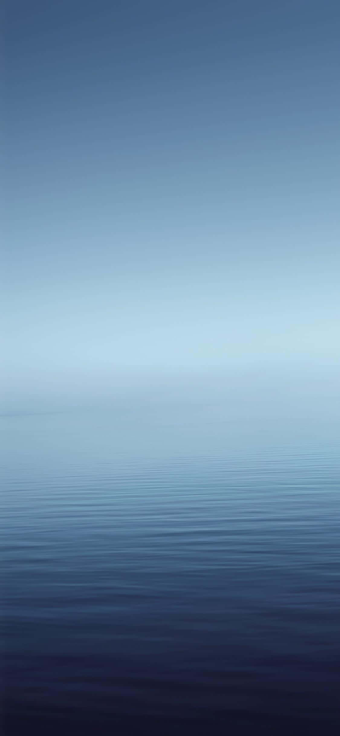 isang asul na karagatan na may puting horizon Wallpaper