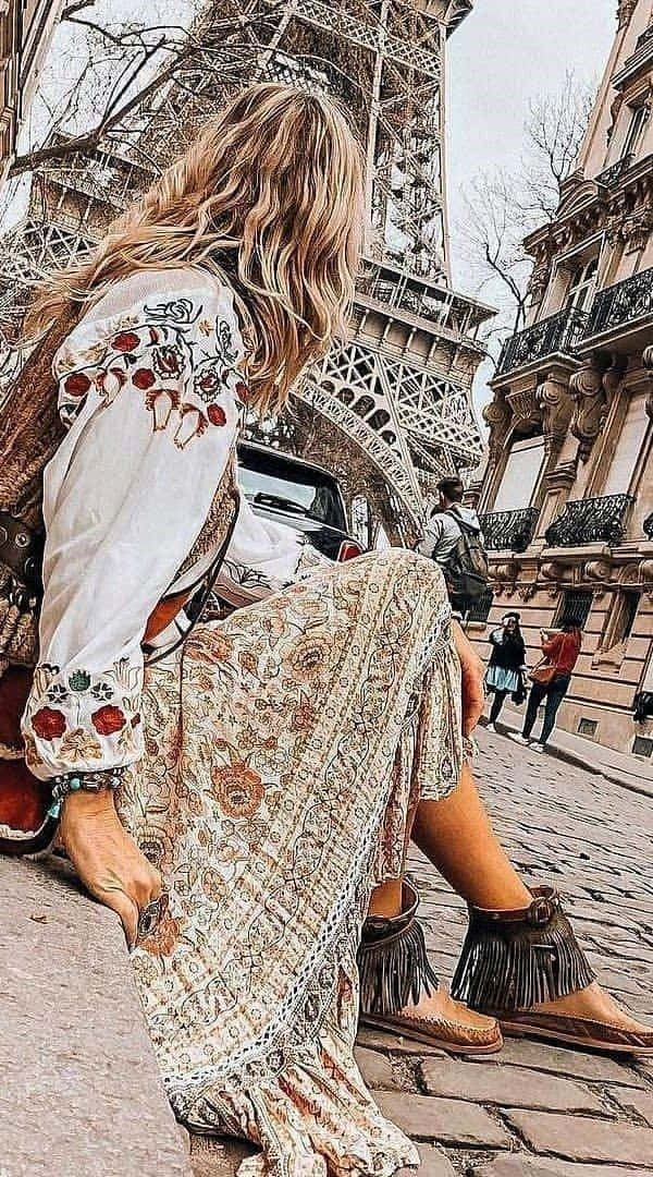 isang babaeng nakaupo sa mga hakbang ng Eiffel Tower Wallpaper