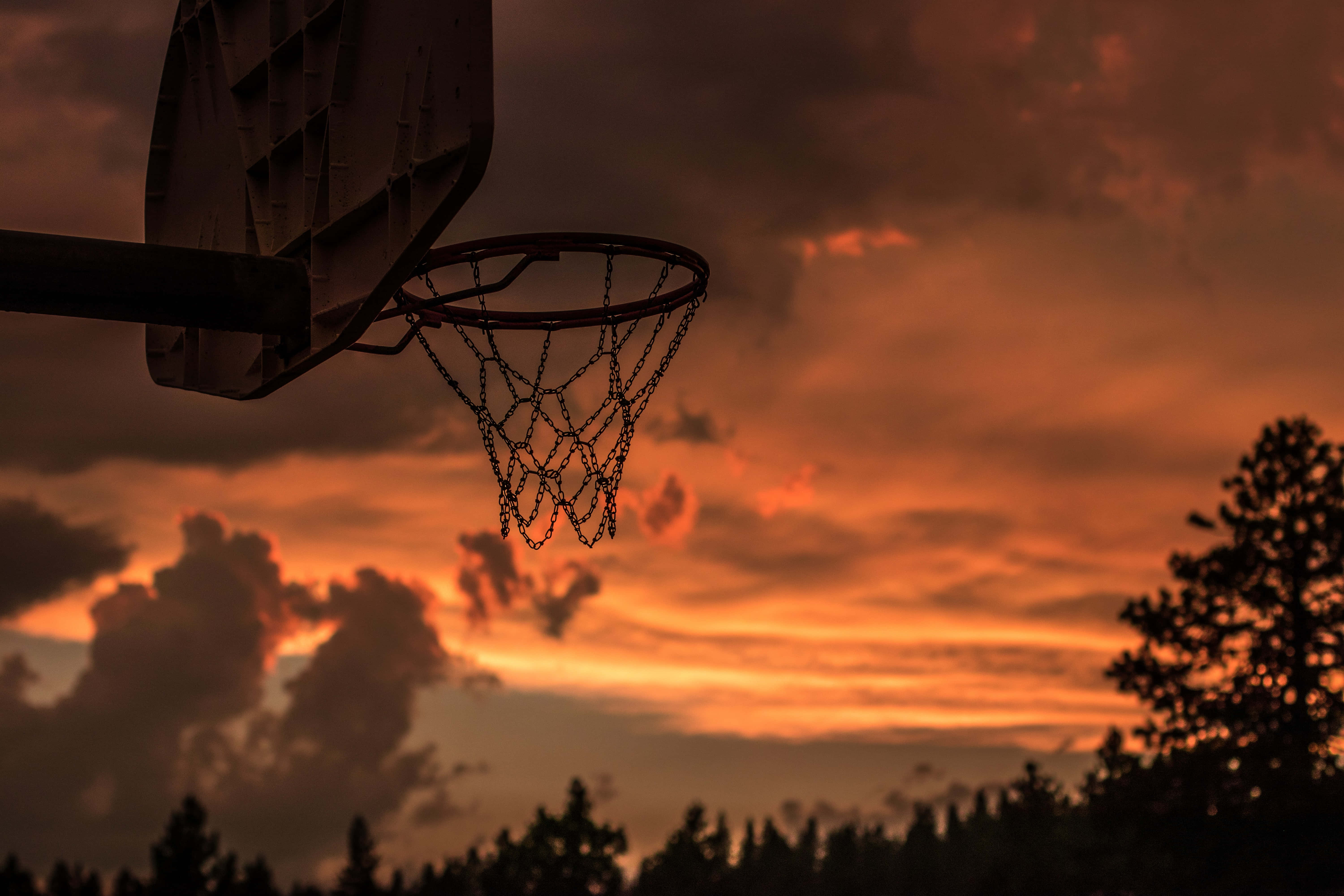 isang basketball hoop na may sunset sky sa likod nito Wallpaper