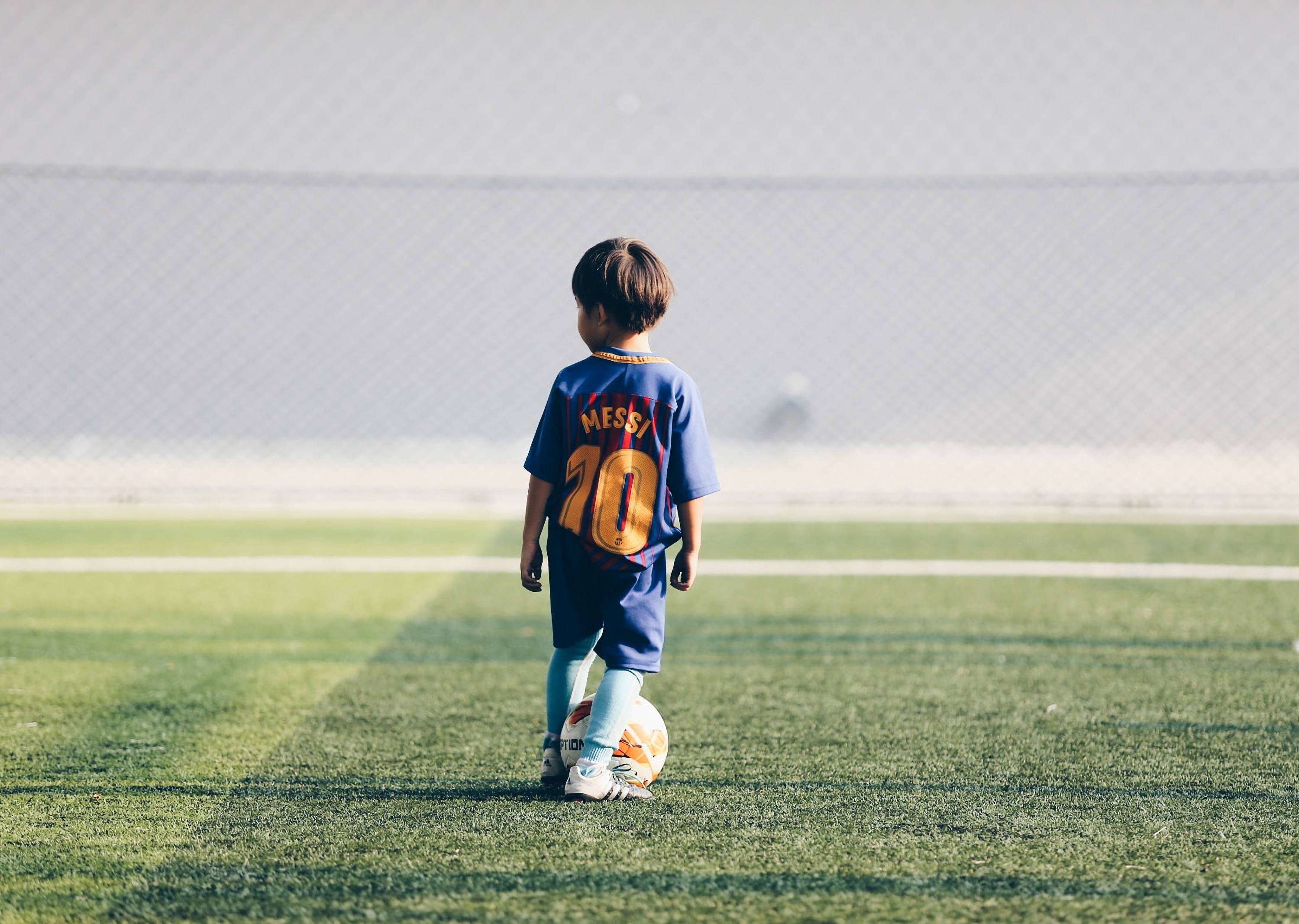 Isang batang may pag-asa ang umaasa na balang araw ay maisuot ang jersey ni Lionel Messi. Wallpaper