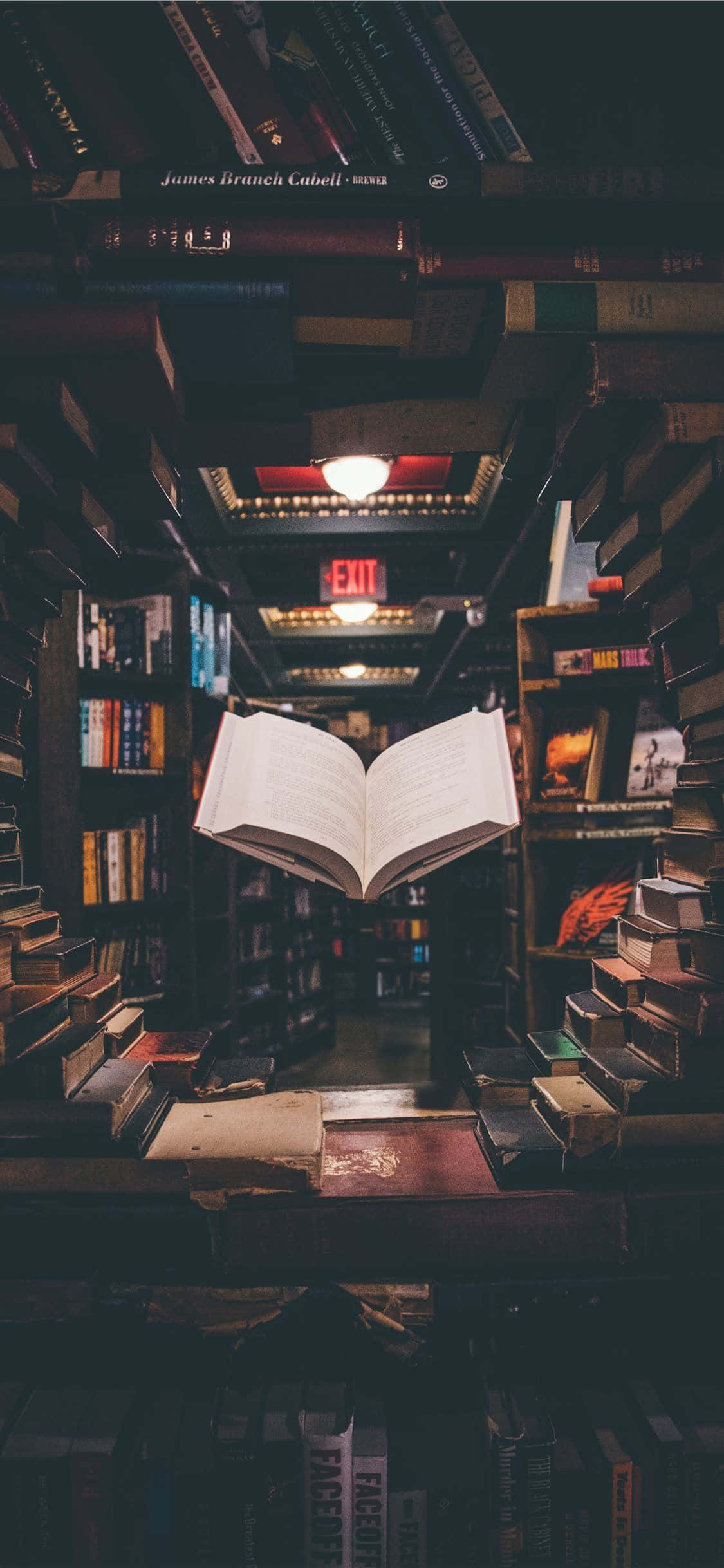 isang bukas na libro sa isang aparador sa isang bookstore Wallpaper