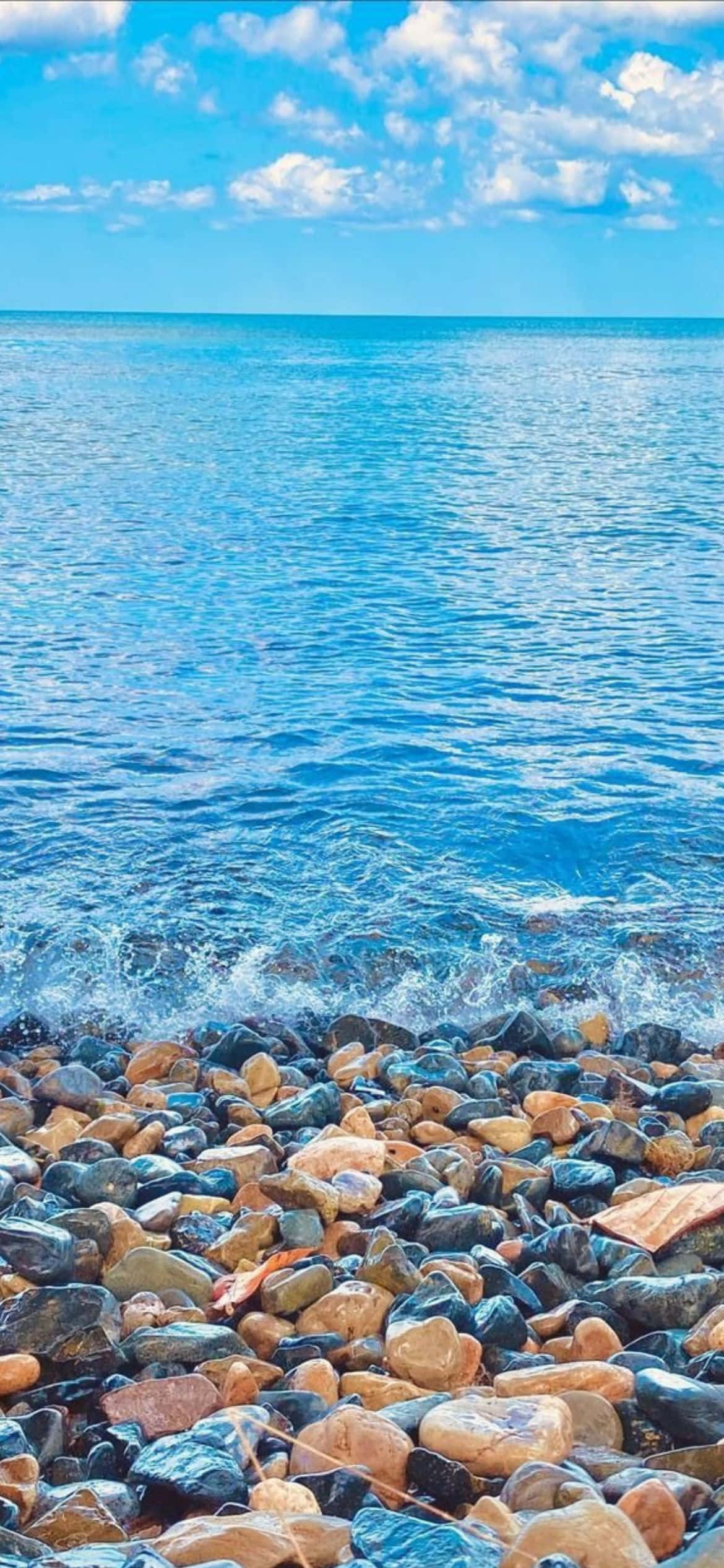 isang dalampasigan na may mga bato at tubig Wallpaper