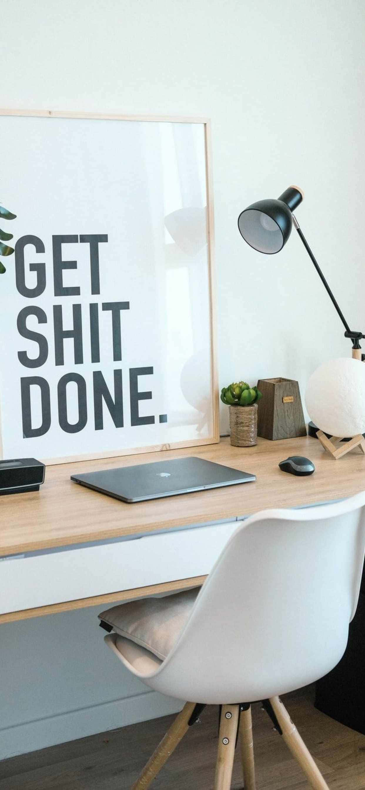 isang desk na may poster na nagsasabing get shit done Wallpaper