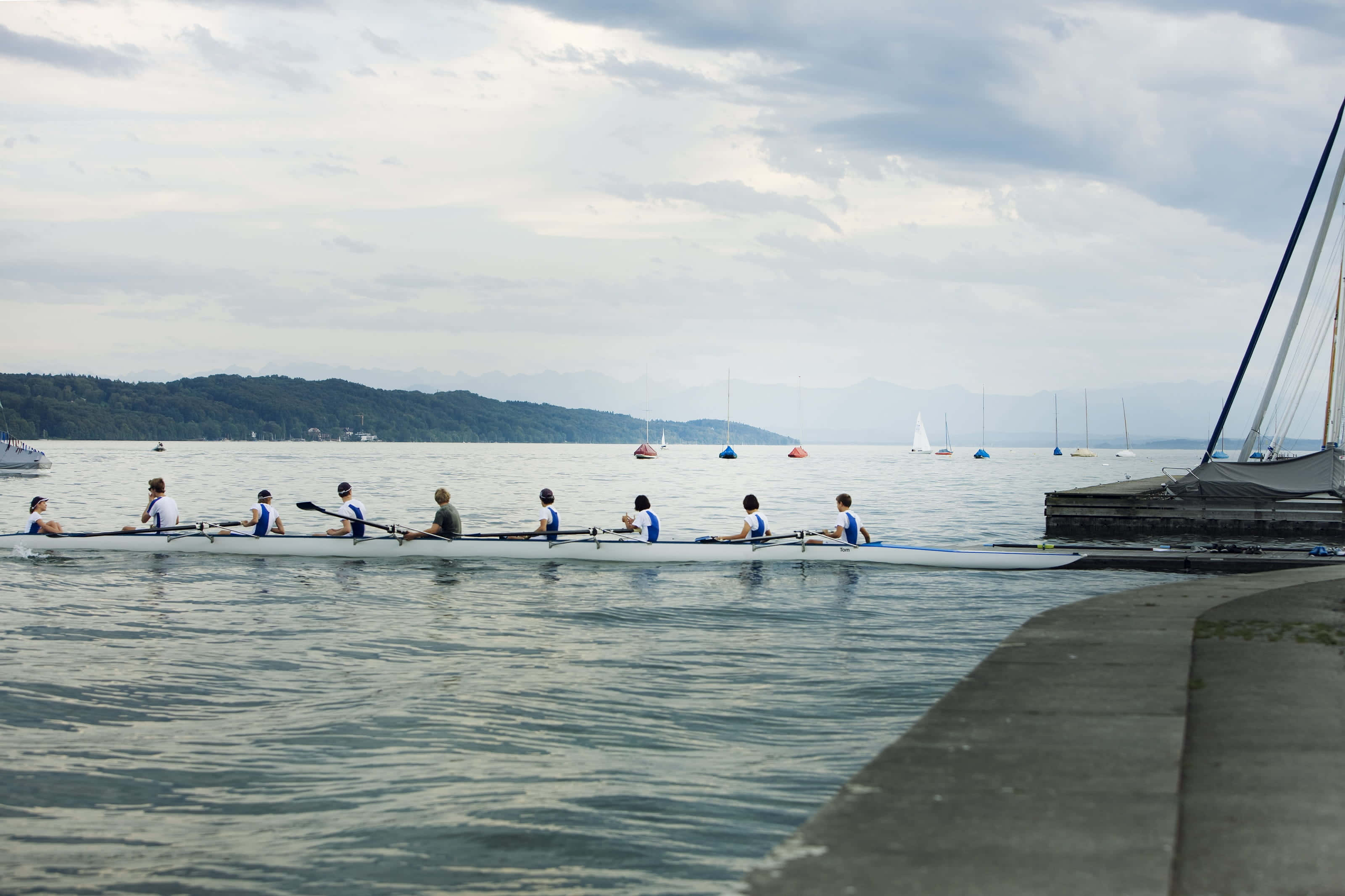 isang grupo ng mga tao na sumasagwan ng bangka Wallpaper
