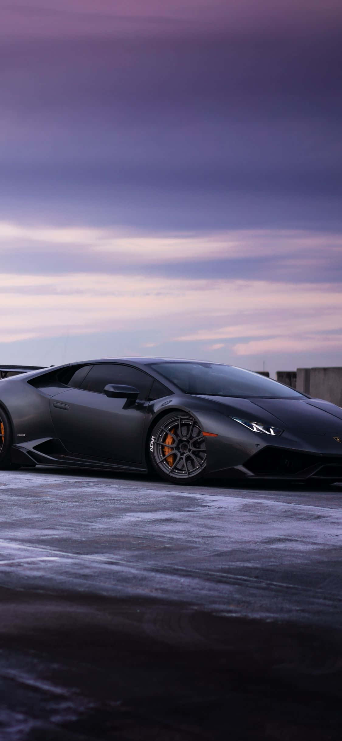isang itim na lamborghini na nakaparada sa isang niyebeng kalsada Wallpaper