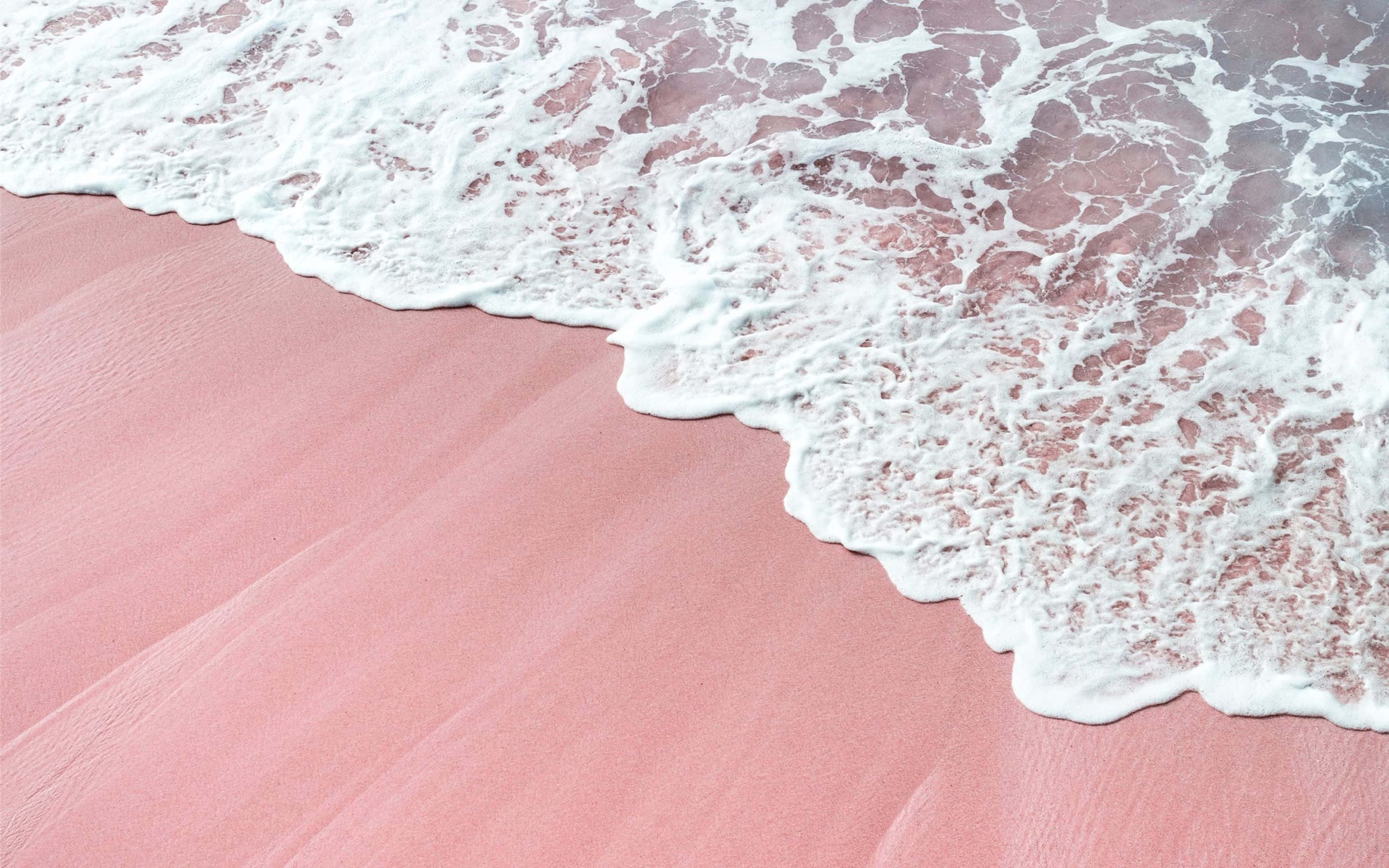 isang kulay rosas na dalampasigan na may mga alon at rosas na buhangin Wallpaper