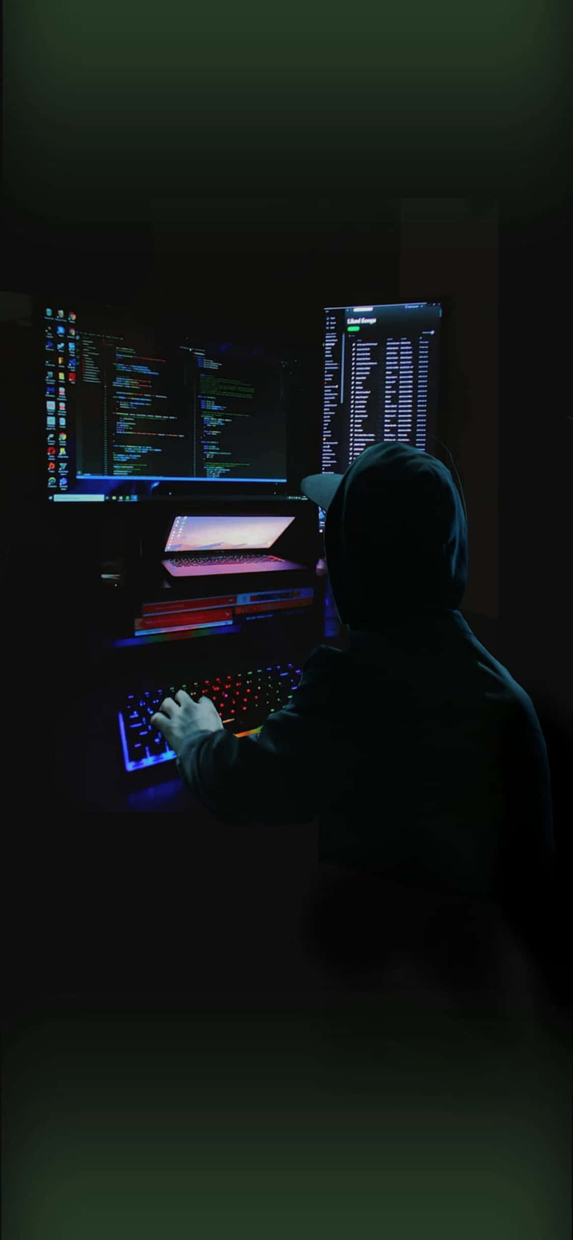isang lalaki ay naka-upo sa computer sa dilim Wallpaper