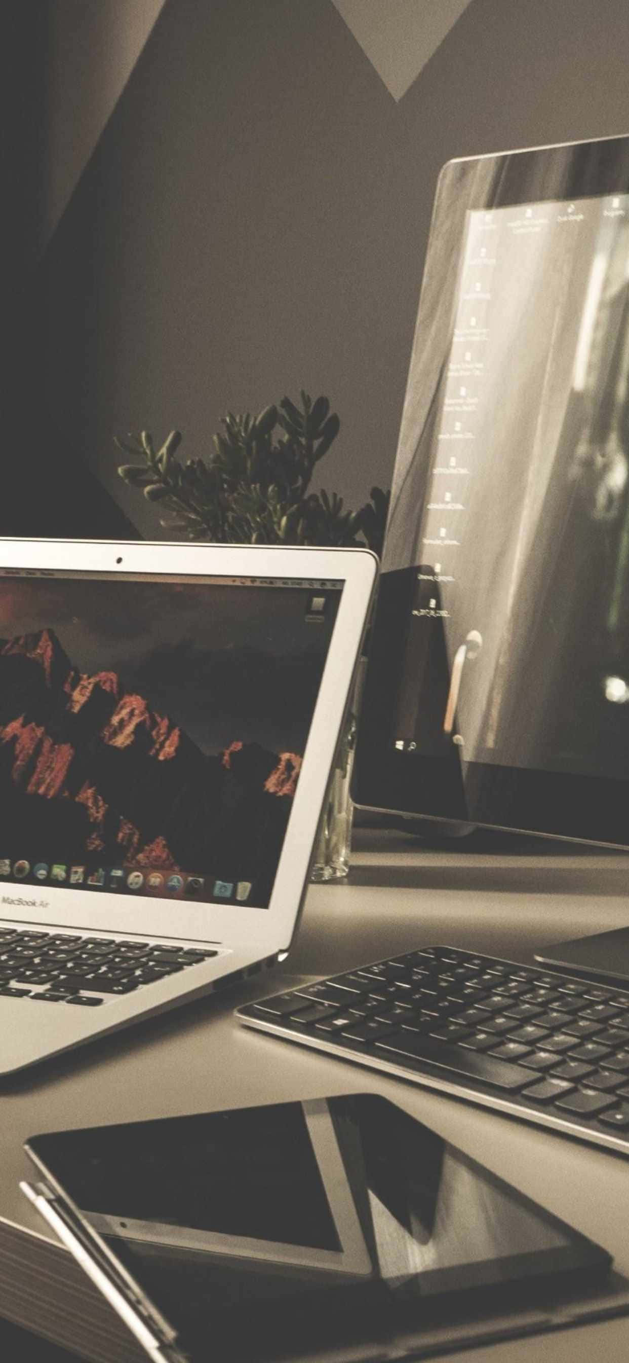 isang laptop, tablet, at telepono sa isang desk Wallpaper