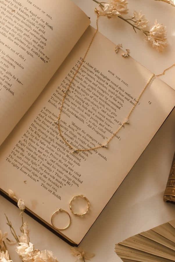 isang libro na may kwintas at singsing dito Wallpaper