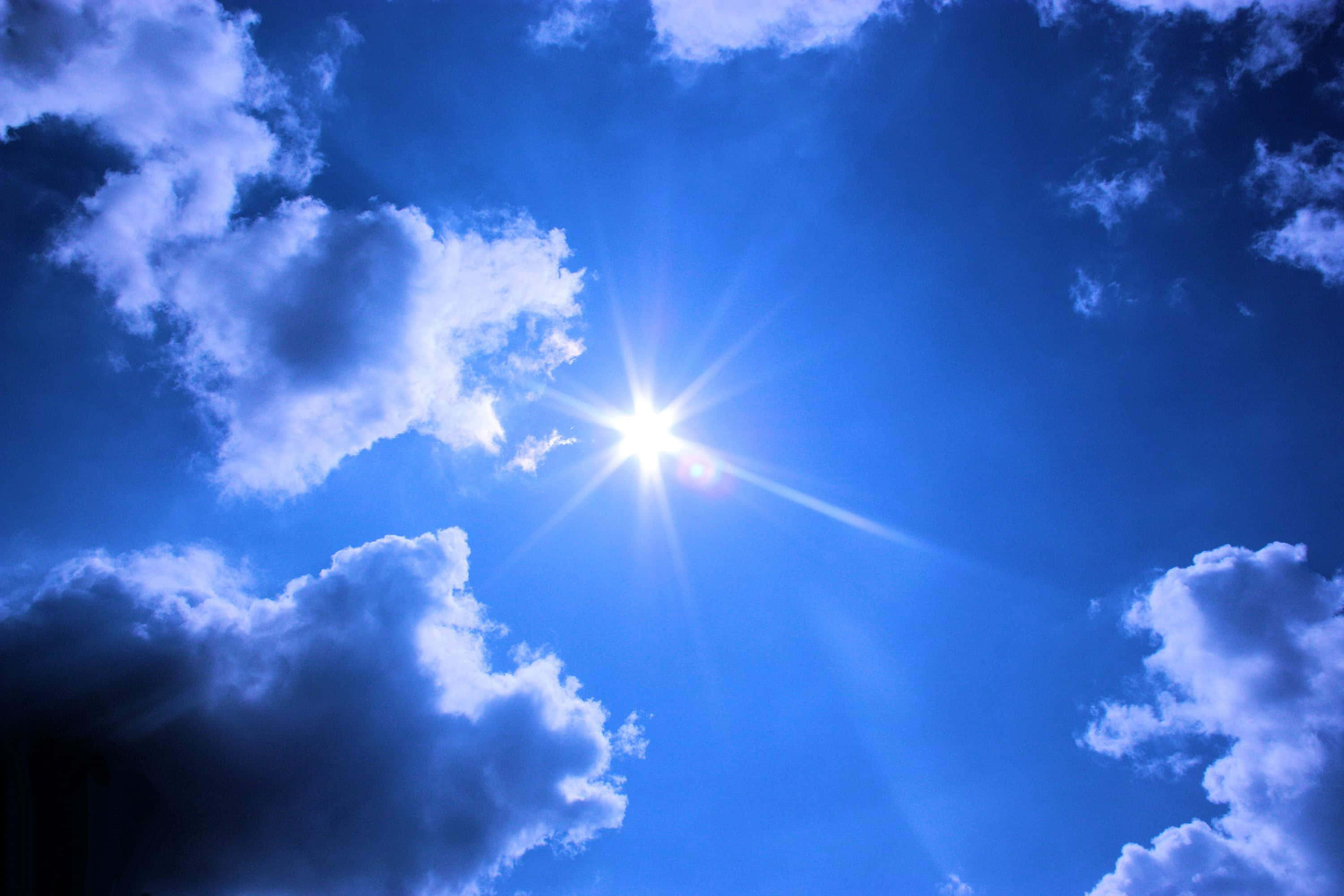 Isang magandang asul na langit na may mga malalambot na puting ulap Wallpaper