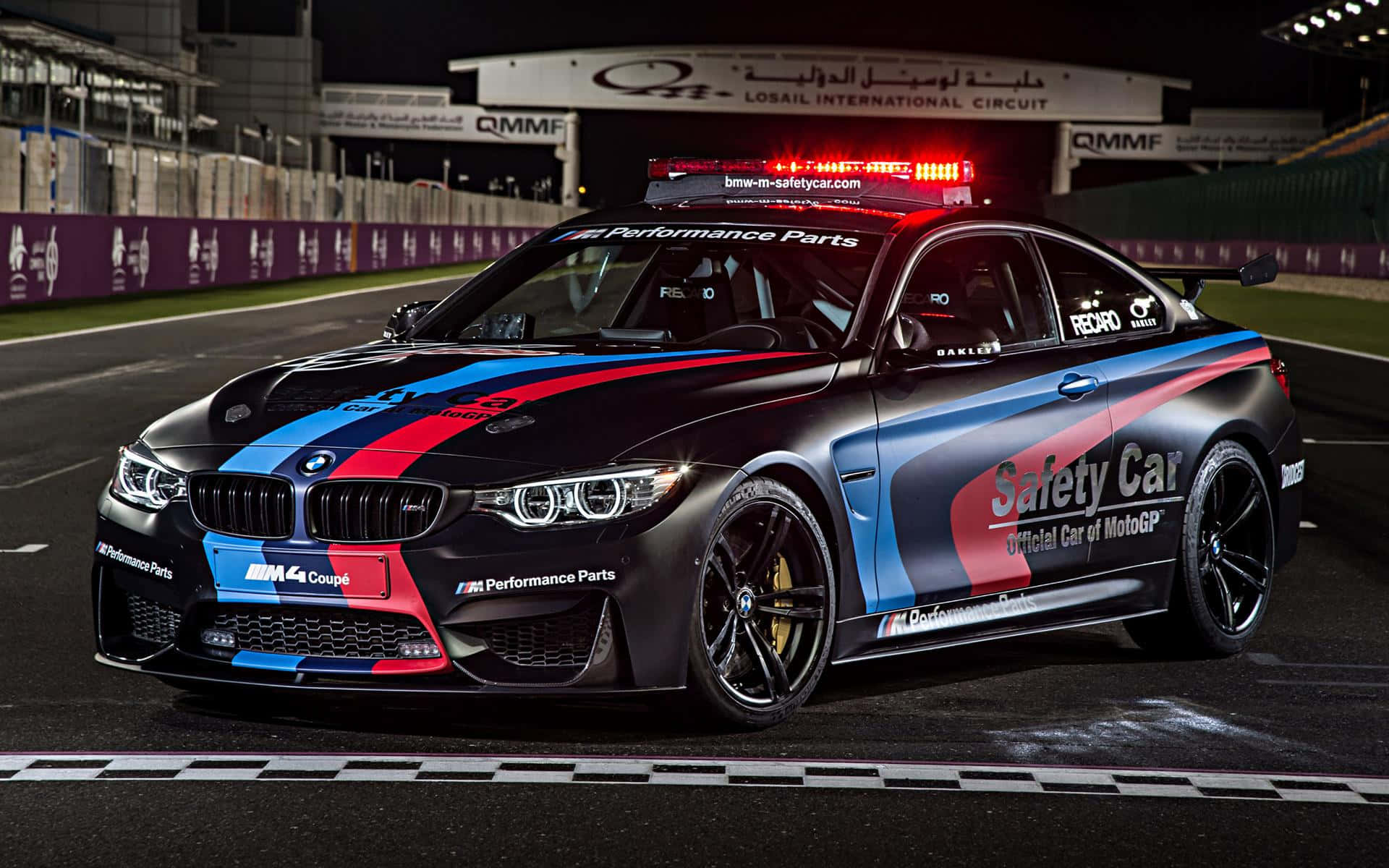 Isang Makinis at Modern na Safety Car na Namumuno sa Karera sa Track Wallpaper