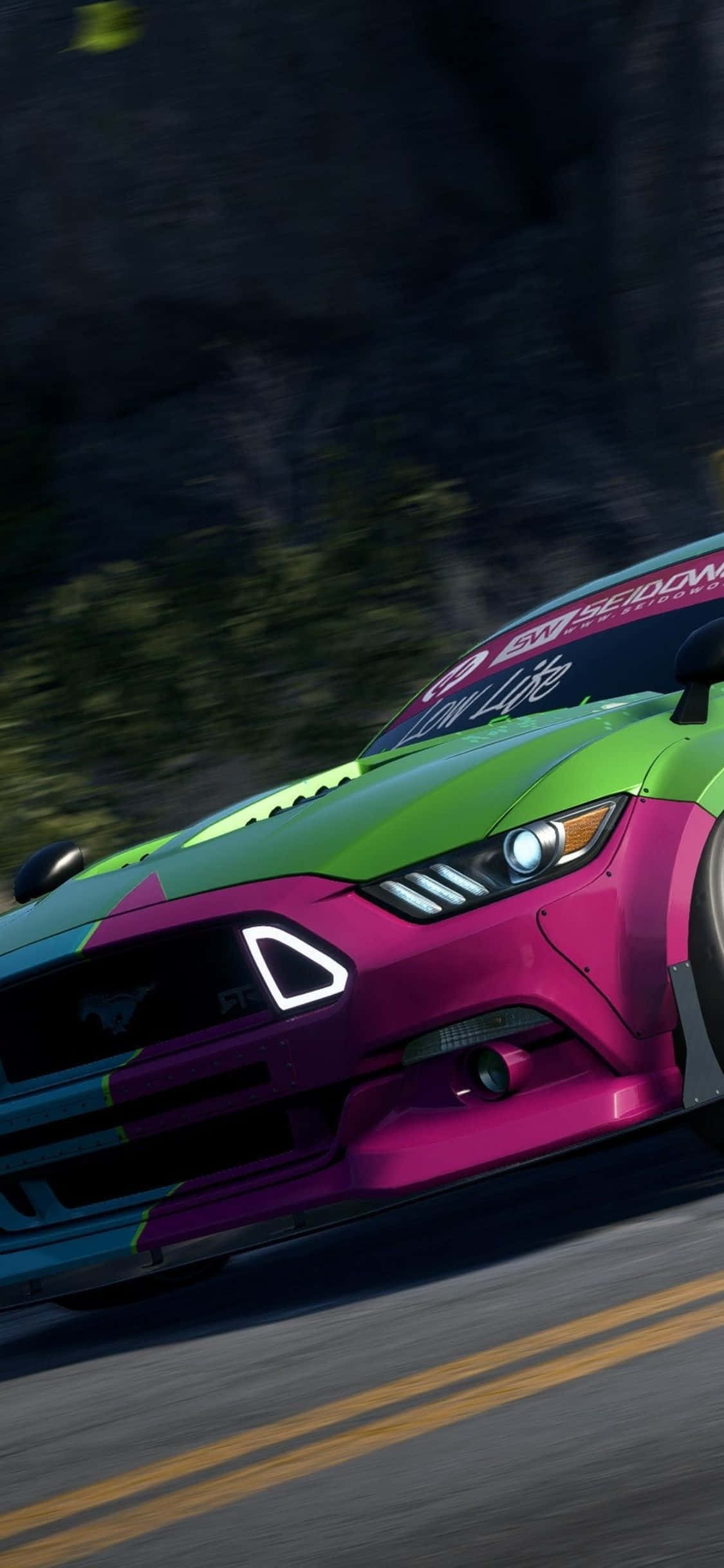 isang makulay na mustang racing car ay nagdadrive pababa ng isang bundok Wallpaper
