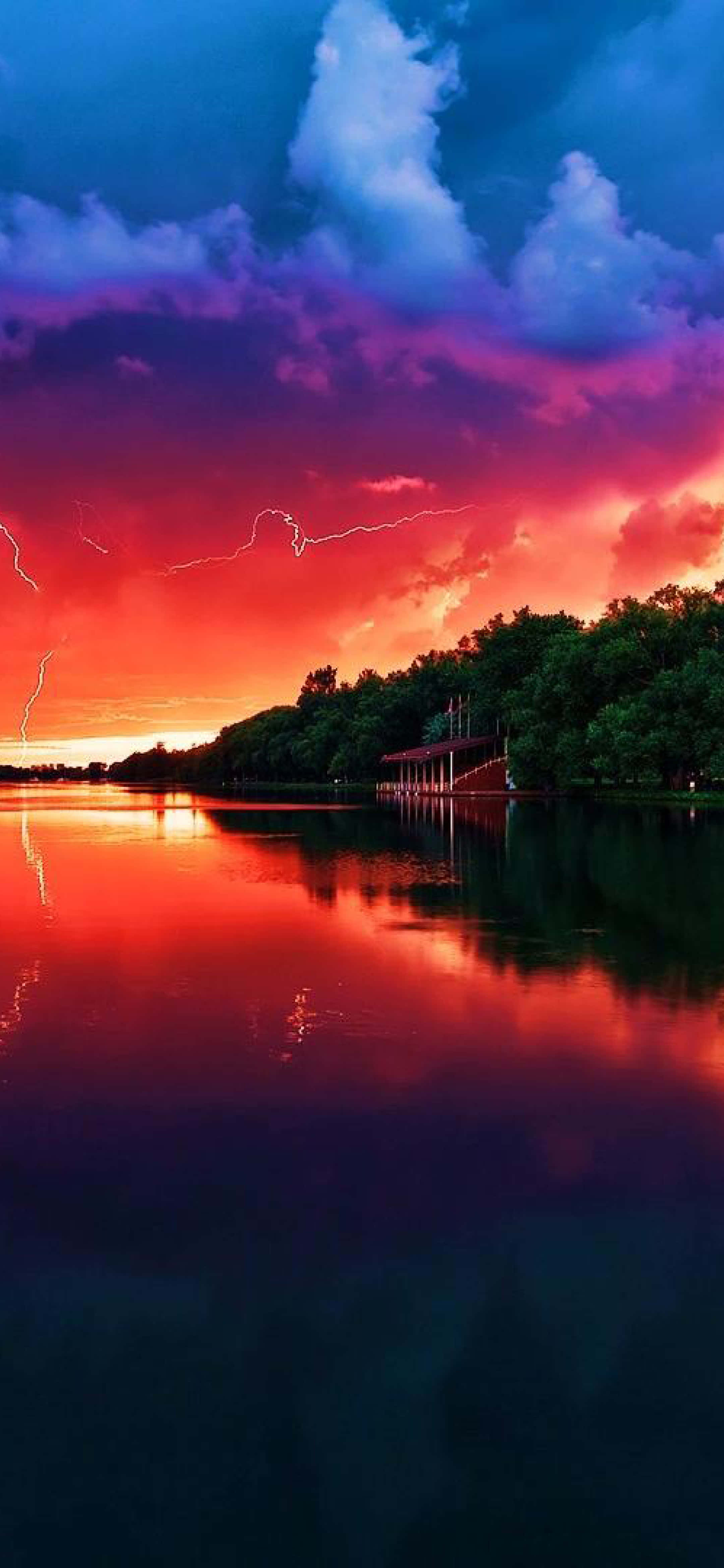 isang makulay na sunset sa ibabaw ng lawa na may kidlat Wallpaper