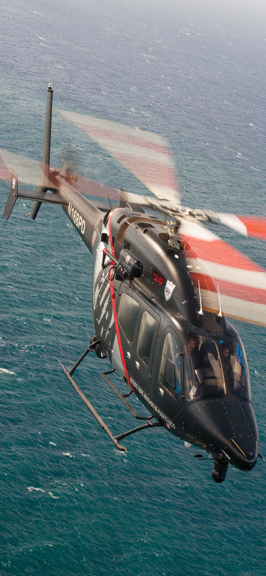 Isang mapangahas na paglipad ng helikopter sa ibabaw ng isang elektrikong asul na horizon. Wallpaper