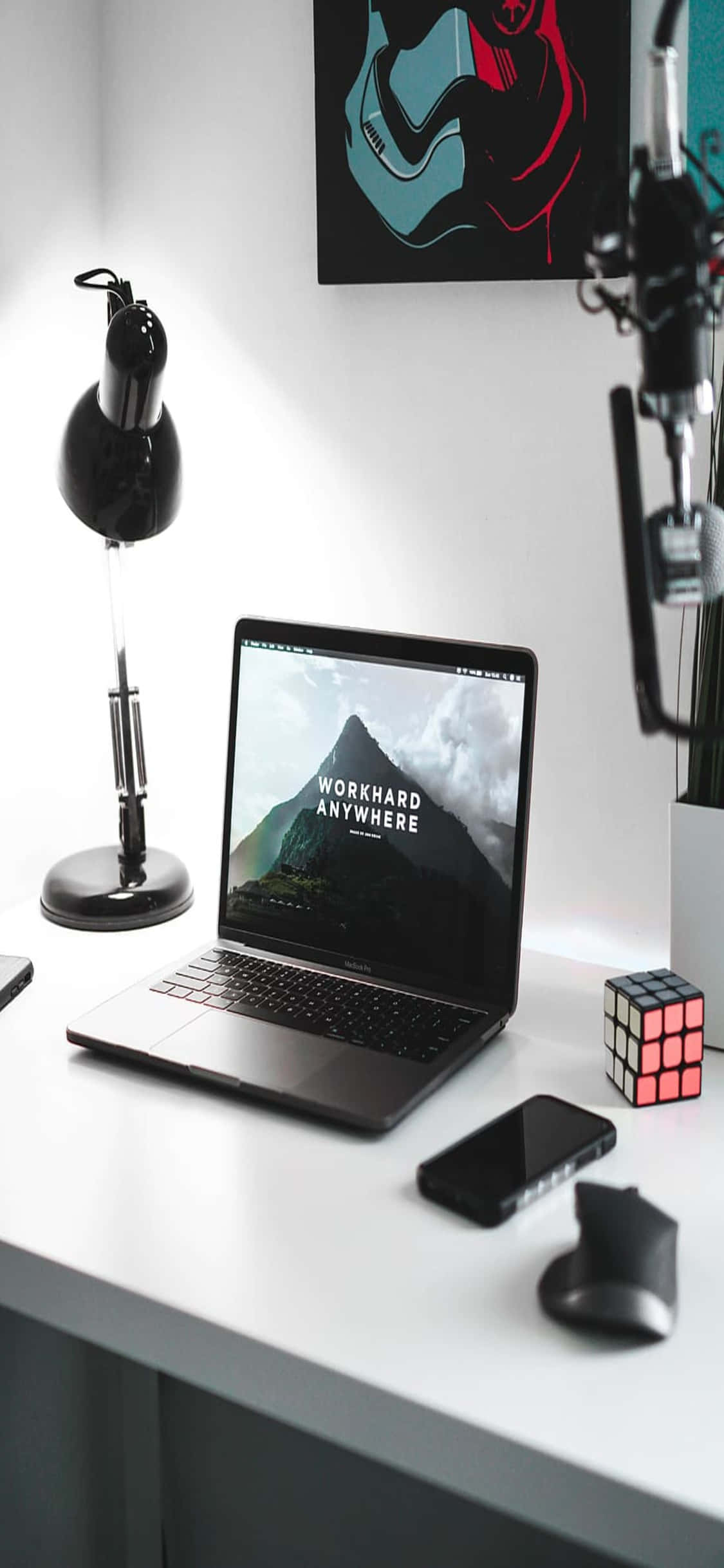 isang mesa na may laptop, telepono, at isang lampara Wallpaper