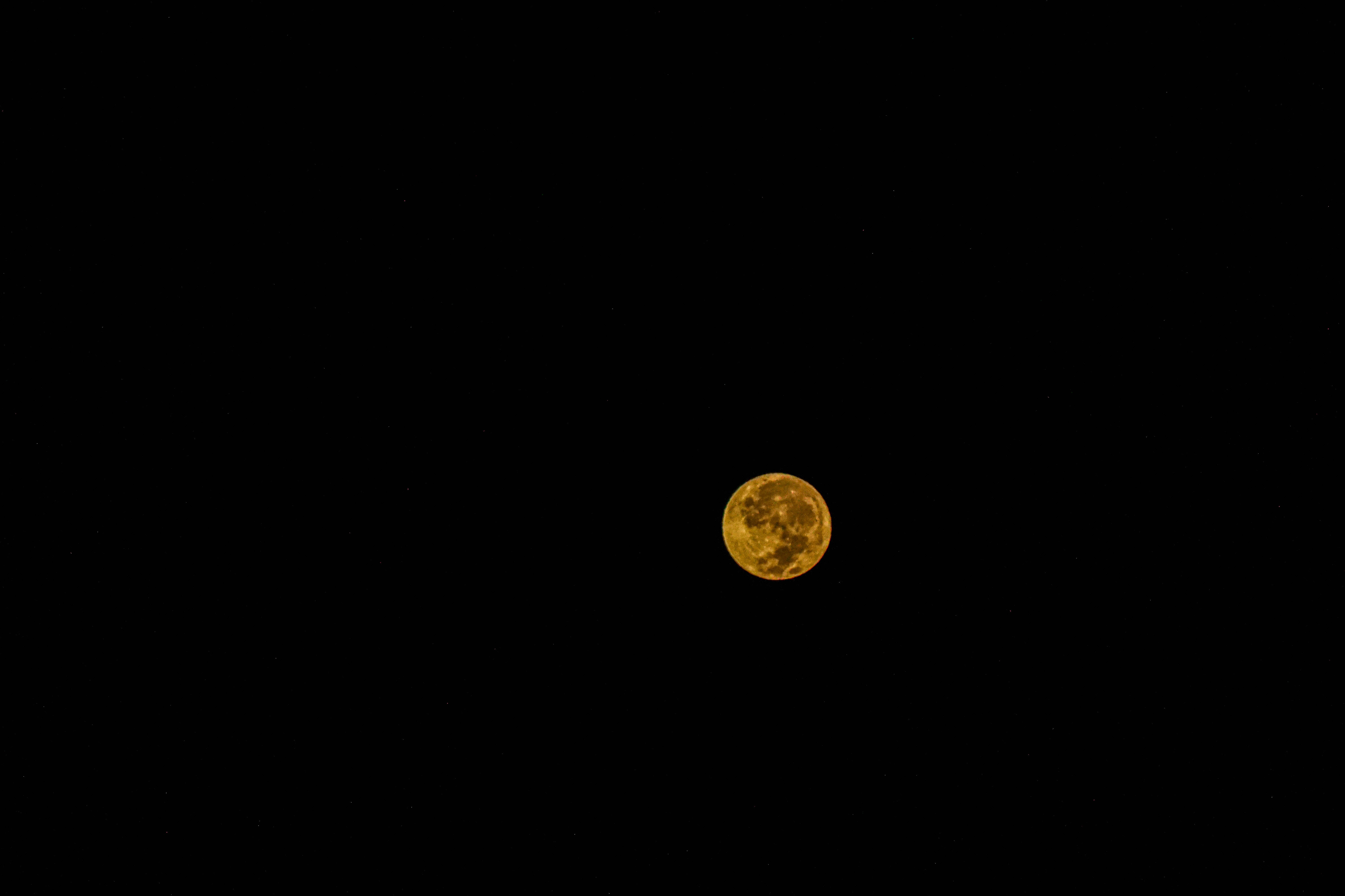 Isang monochromatic na kalangitan sa gabi na puno ng maliwanag na dilaw na buwan Wallpaper