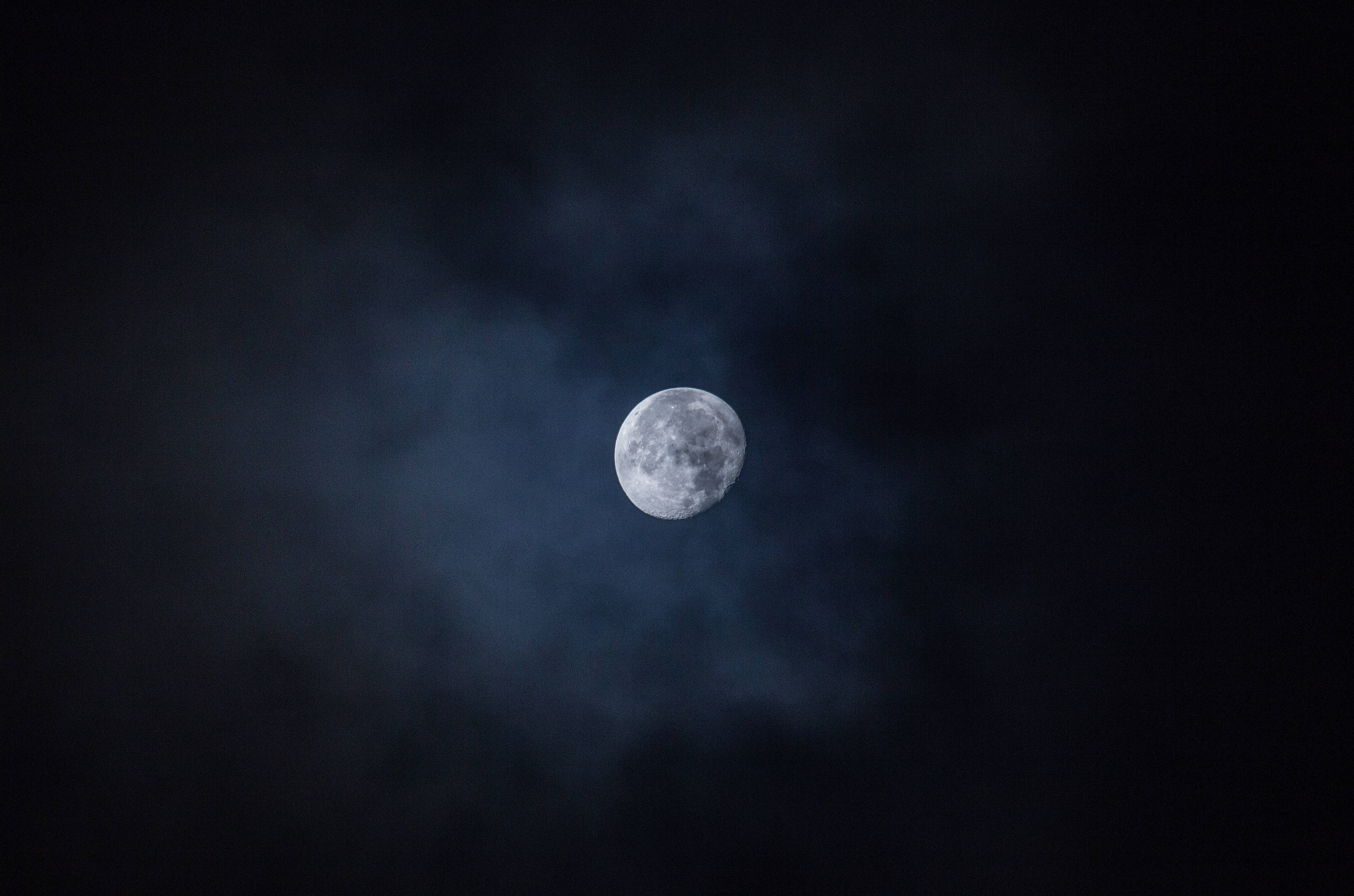 Isang nakakabighaning tanawin ng buwan na napapaligiran ng mabituing kalangitan sa gabi. Wallpaper