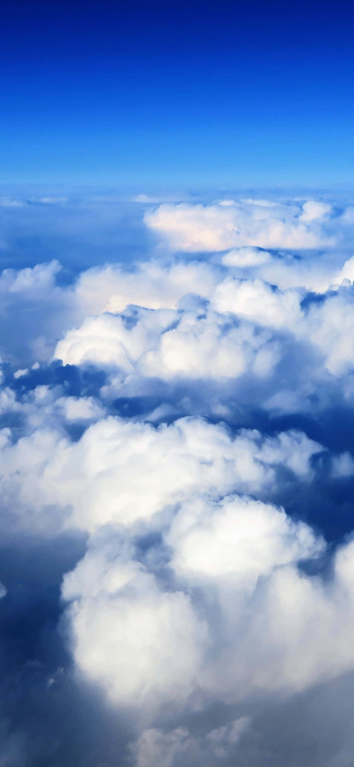 Isang perpektong asul na langit na may magagandang puting na ulap Wallpaper