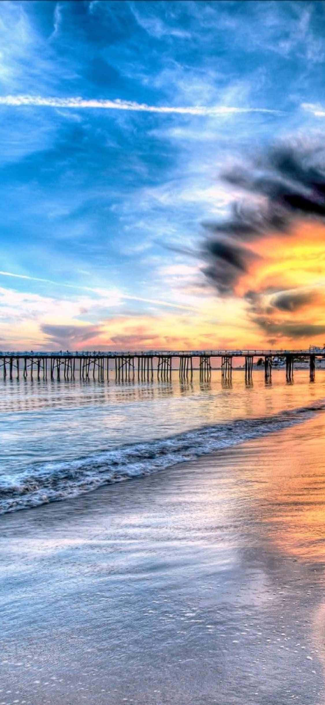 isang pier na may isang paglubog ng araw sa ibabaw ng karagatan Wallpaper