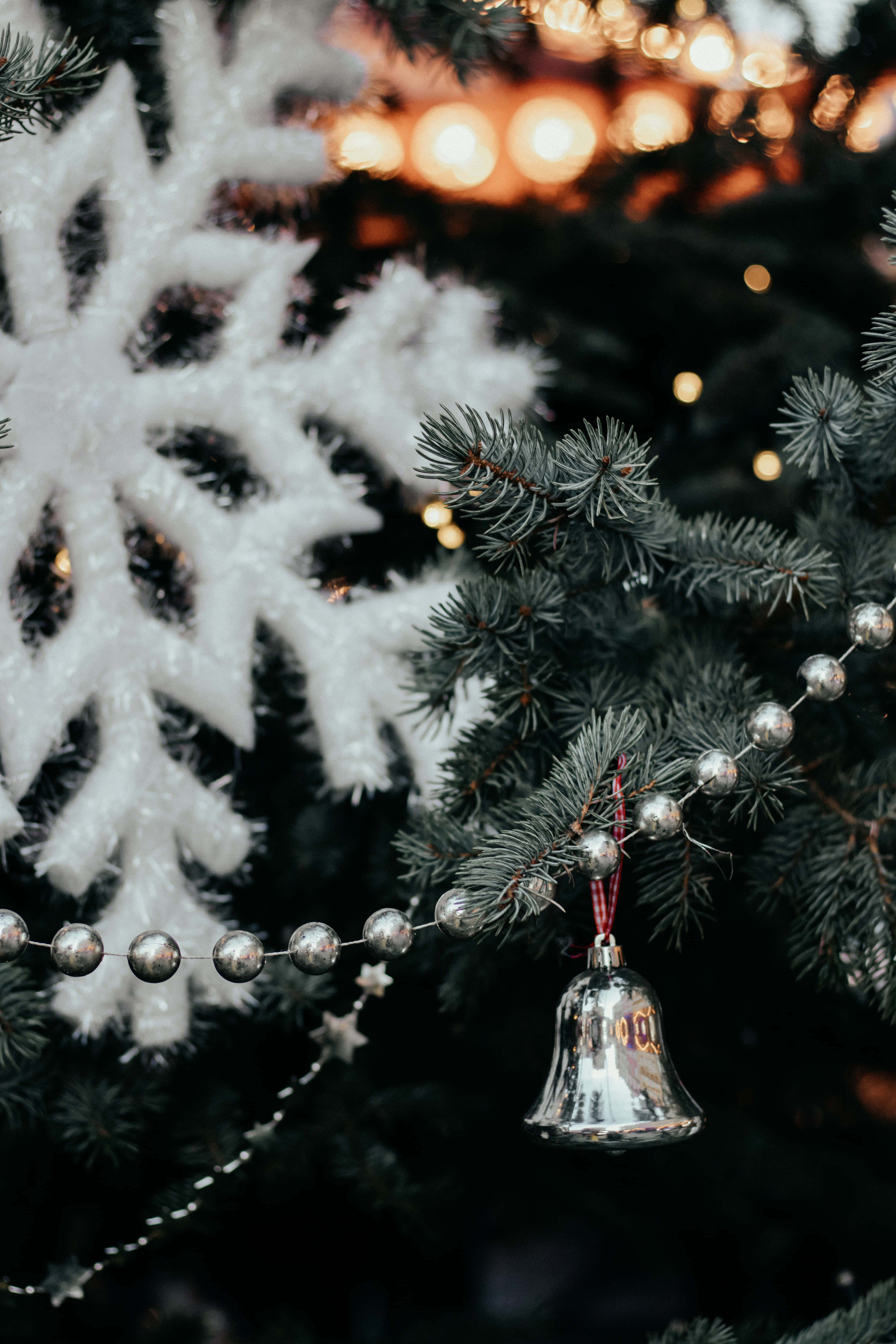 isang puno ng pasko na may kampana at mga snowflake Wallpaper