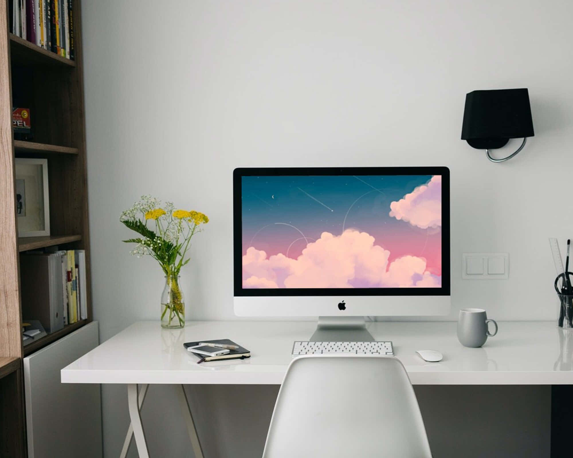 isang puting mesa na may computer at plorera Wallpaper