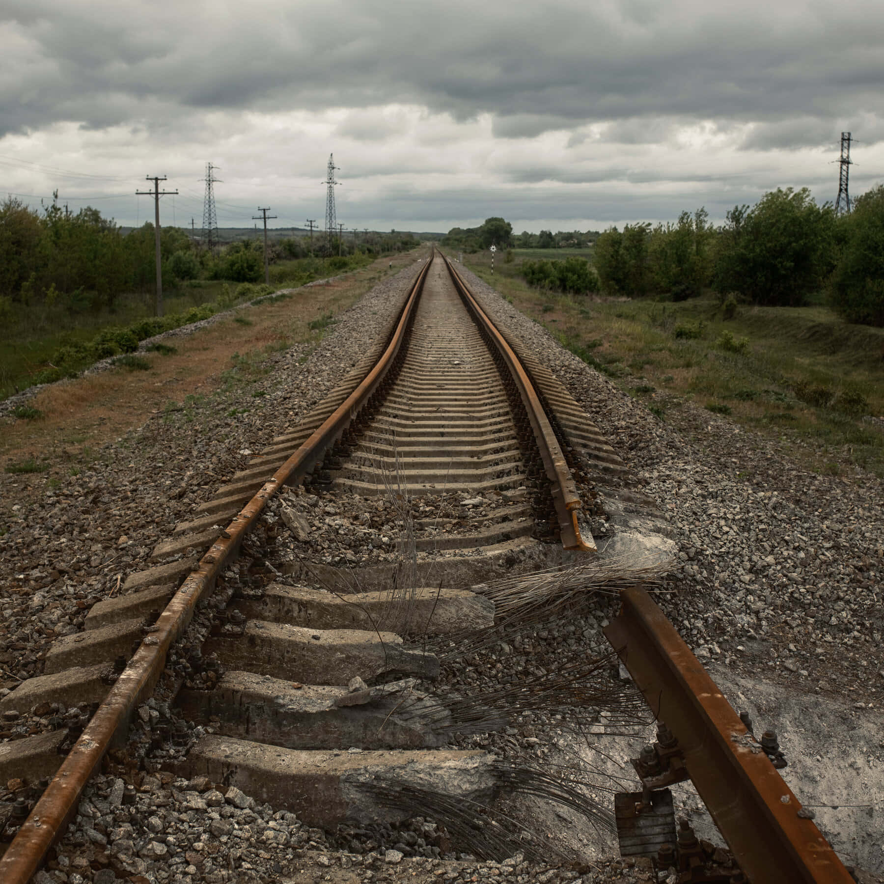 isang riles ng tren sa gitna ng isang bukid Wallpaper
