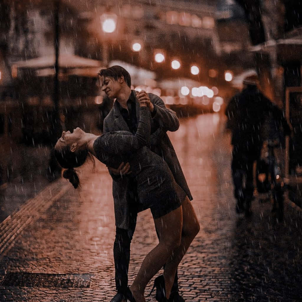 Isang romantikong sandali ng dalawang magkasintahan sa ulan Wallpaper