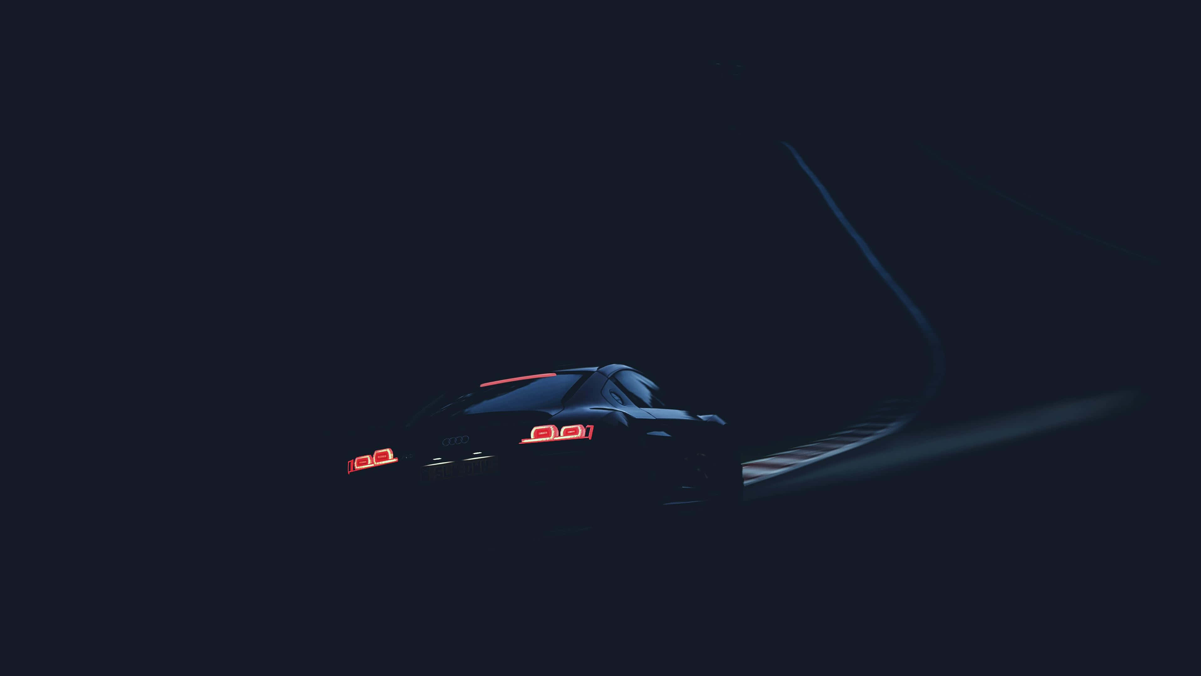 isang sasakyan na nagmamaneho sa madilim na kalsada Wallpaper