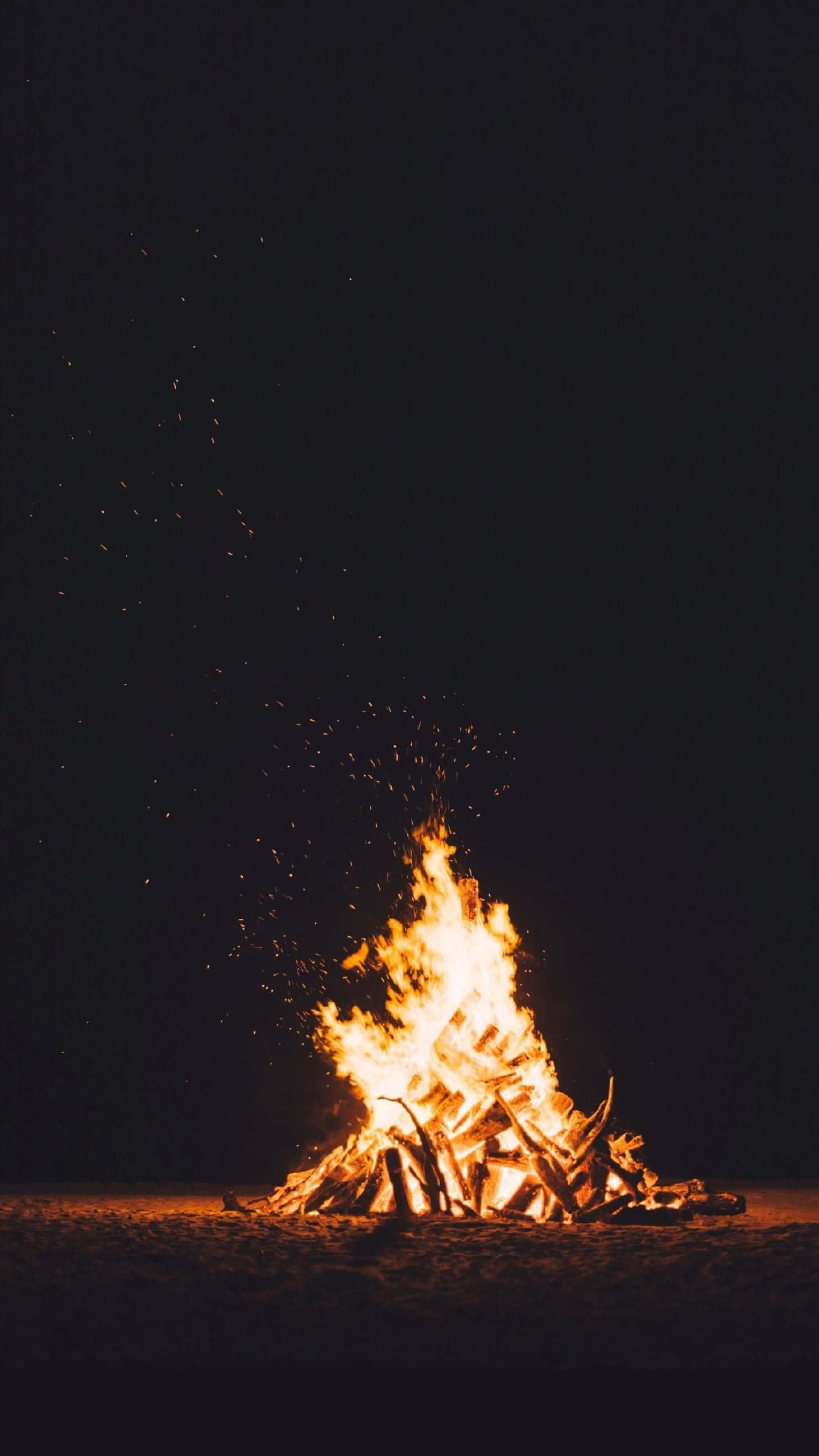 isang siga sa tabing-dagat sa gabi Wallpaper