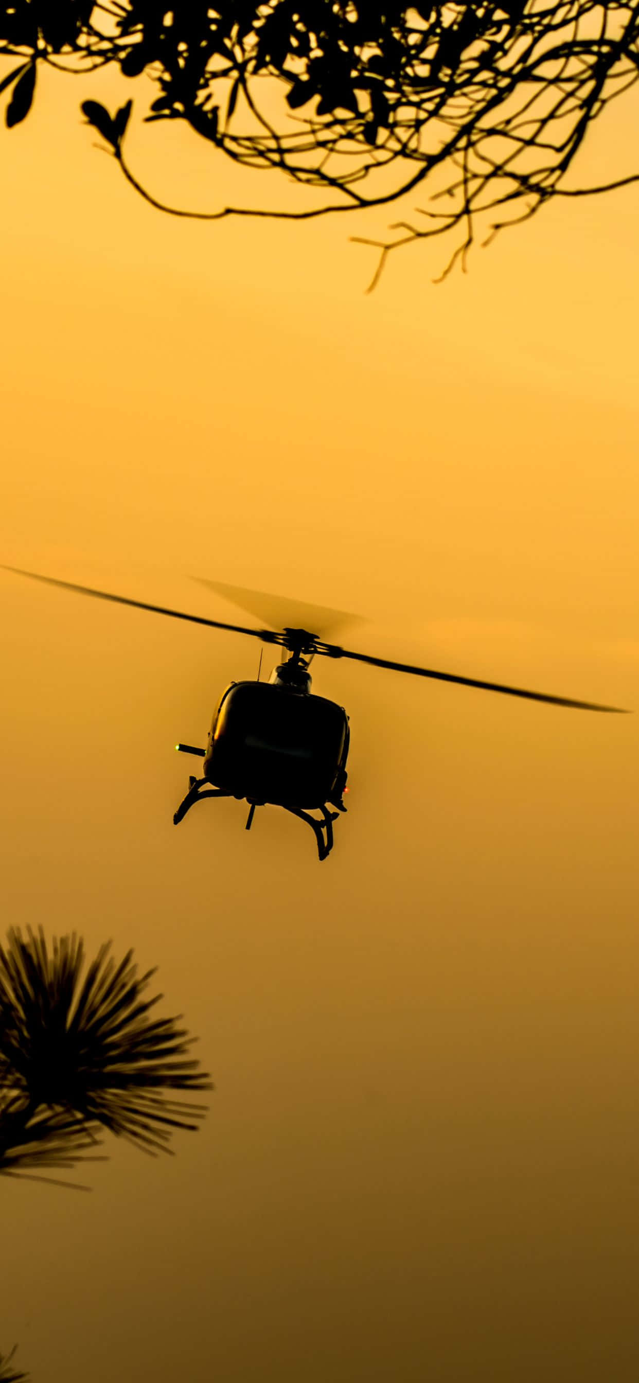 Isang tanawin mula sa himpapawid ng isang makinis na helicopter na nagdadala ng bagong iPhone Xs Max Wallpaper