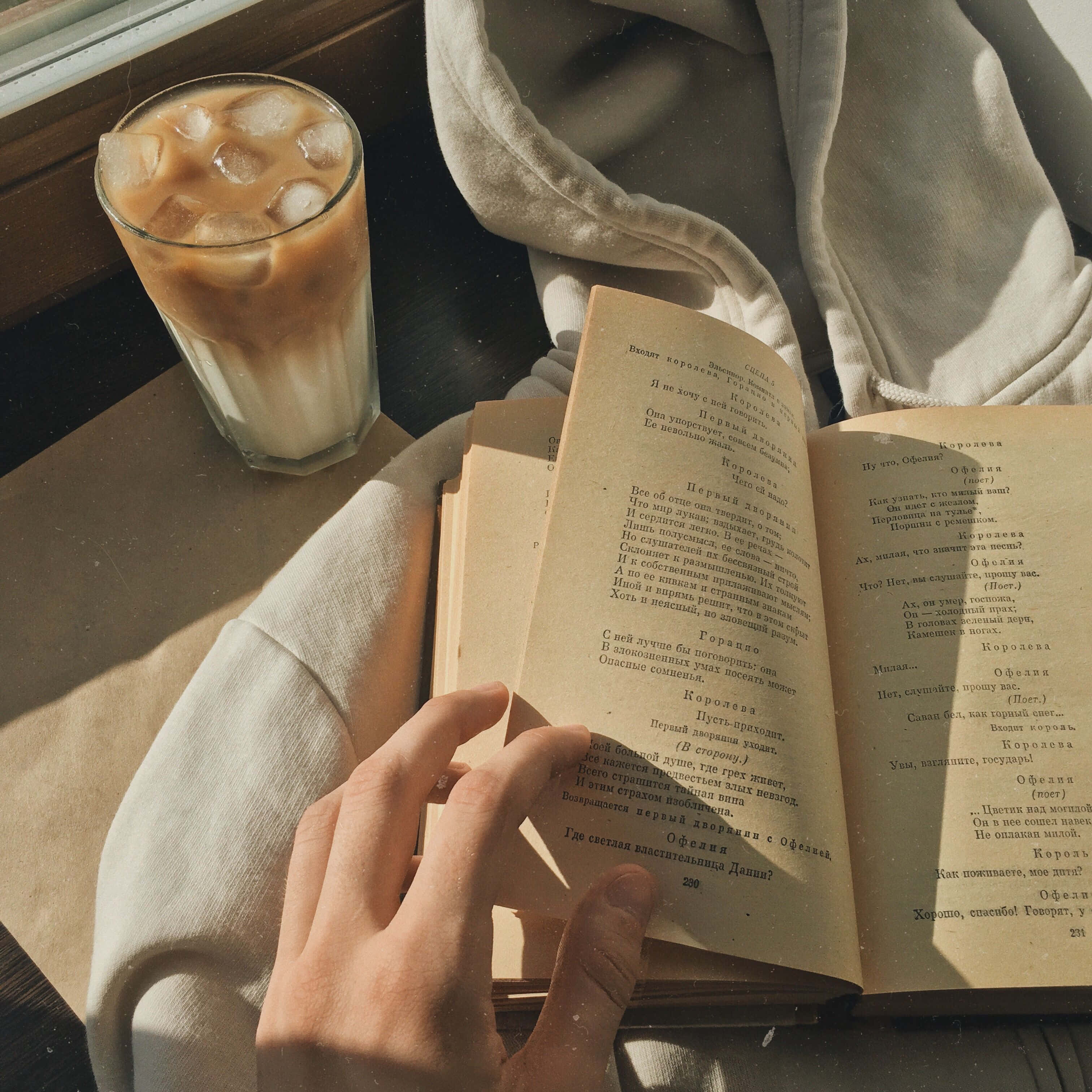 isang tao na nagbabasa ng libro na may kasamang tasa ng kape Wallpaper