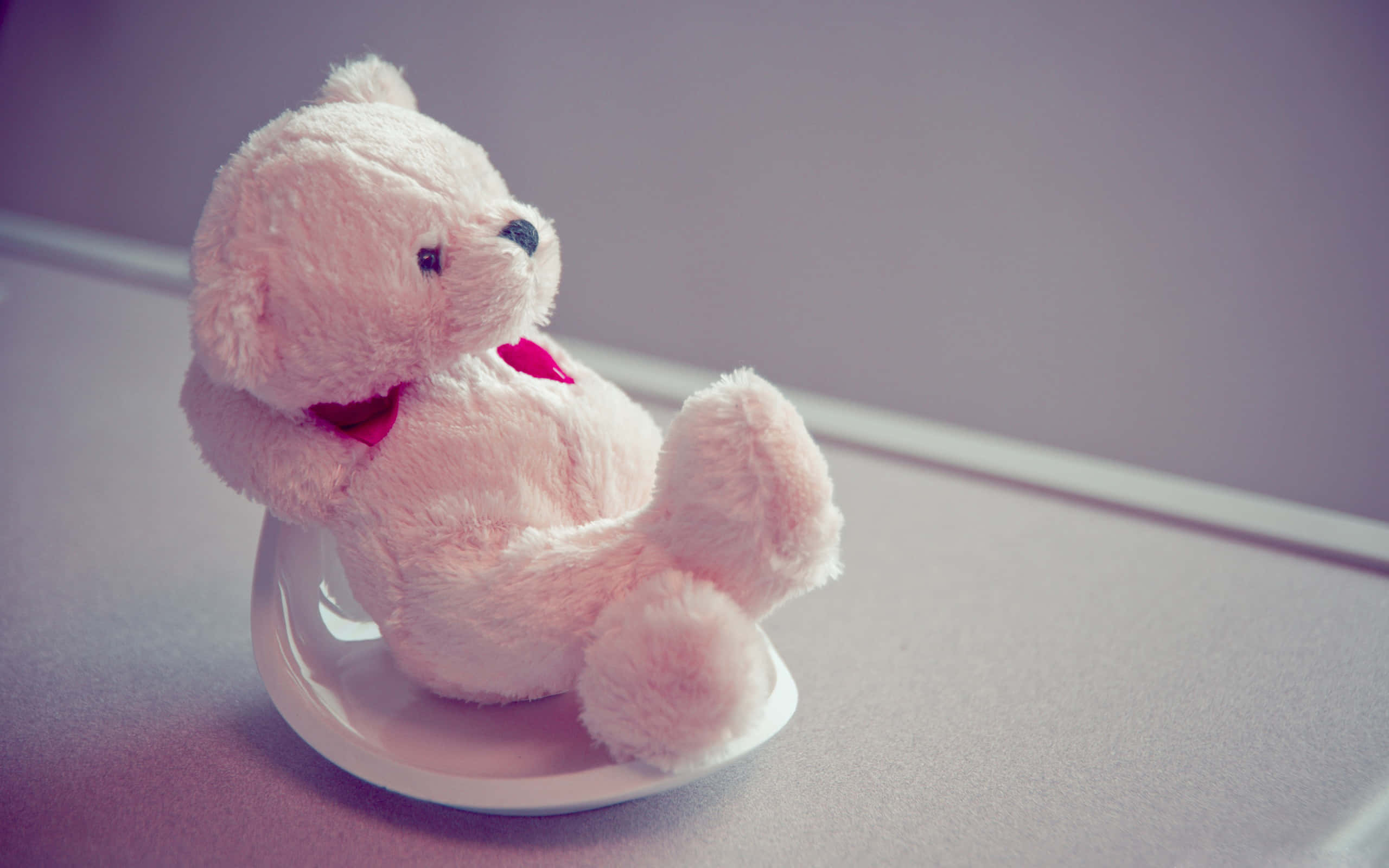 isang teddy bear na nakaupo sa isang upuan Wallpaper